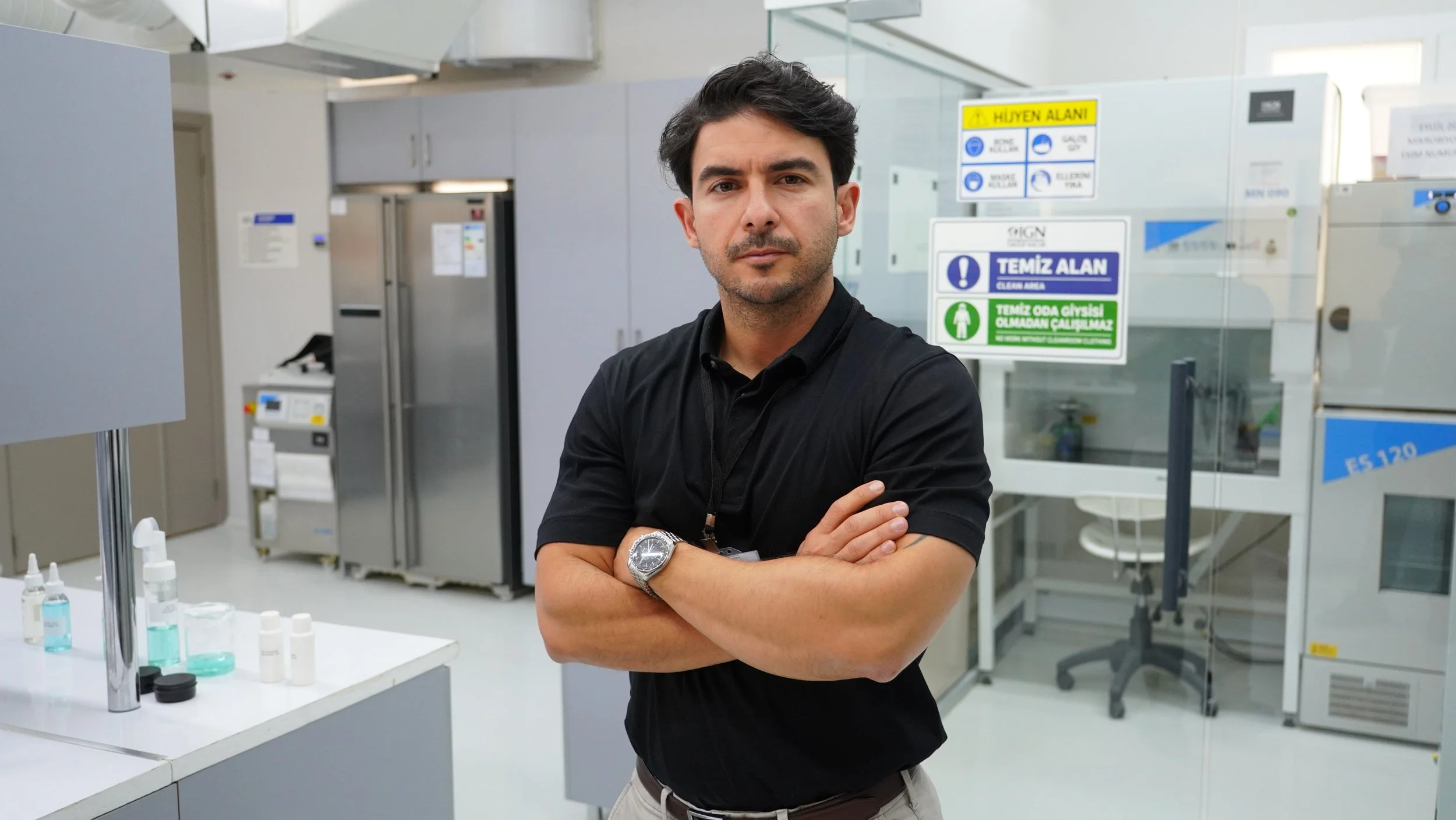 Kentsel bir ortamda gülümseyen gözlüklü genç adam.
