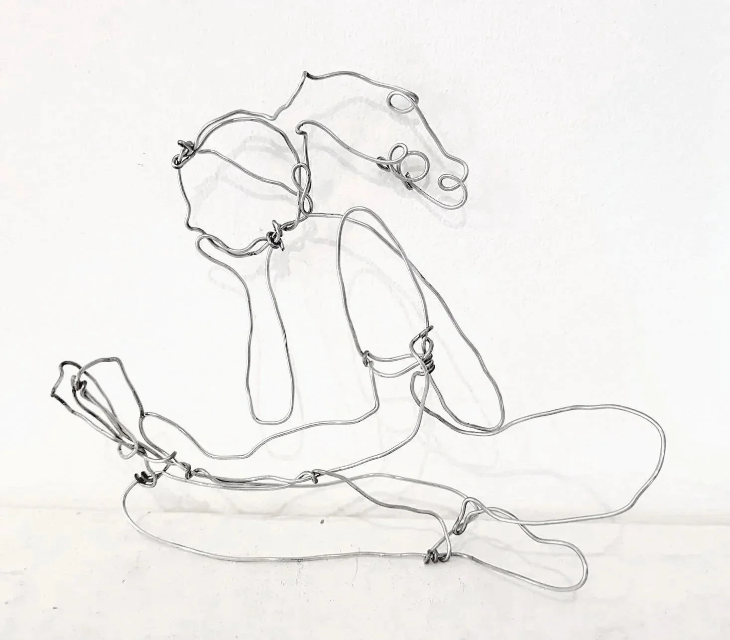 Sculpture d'une femme lisant en tailleur, fil de fer inox 