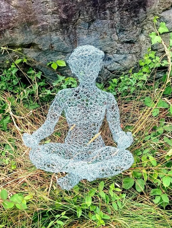 Sculpture de femme qui médite en grillage