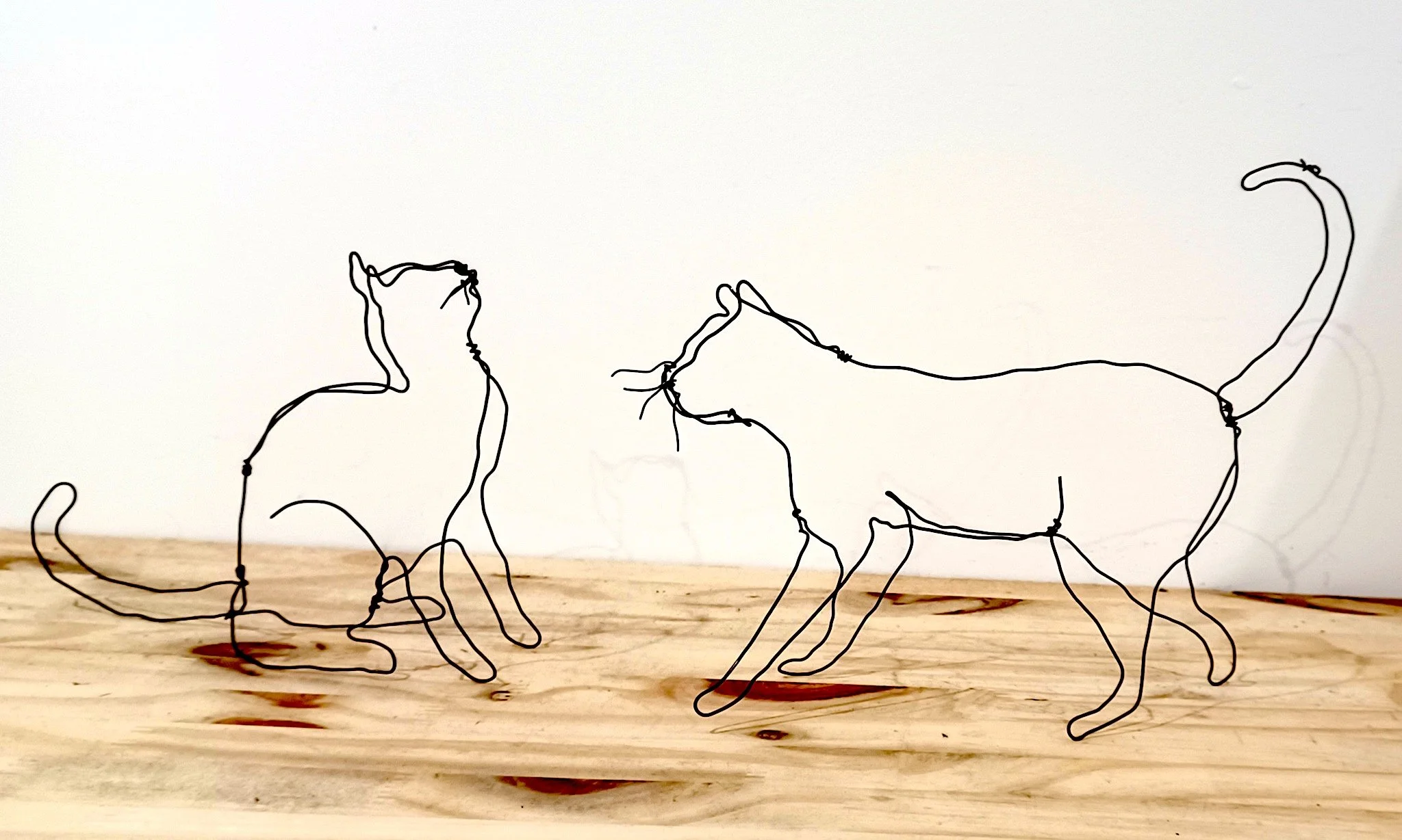 Deux sculptures de chats en fil de fer recuit