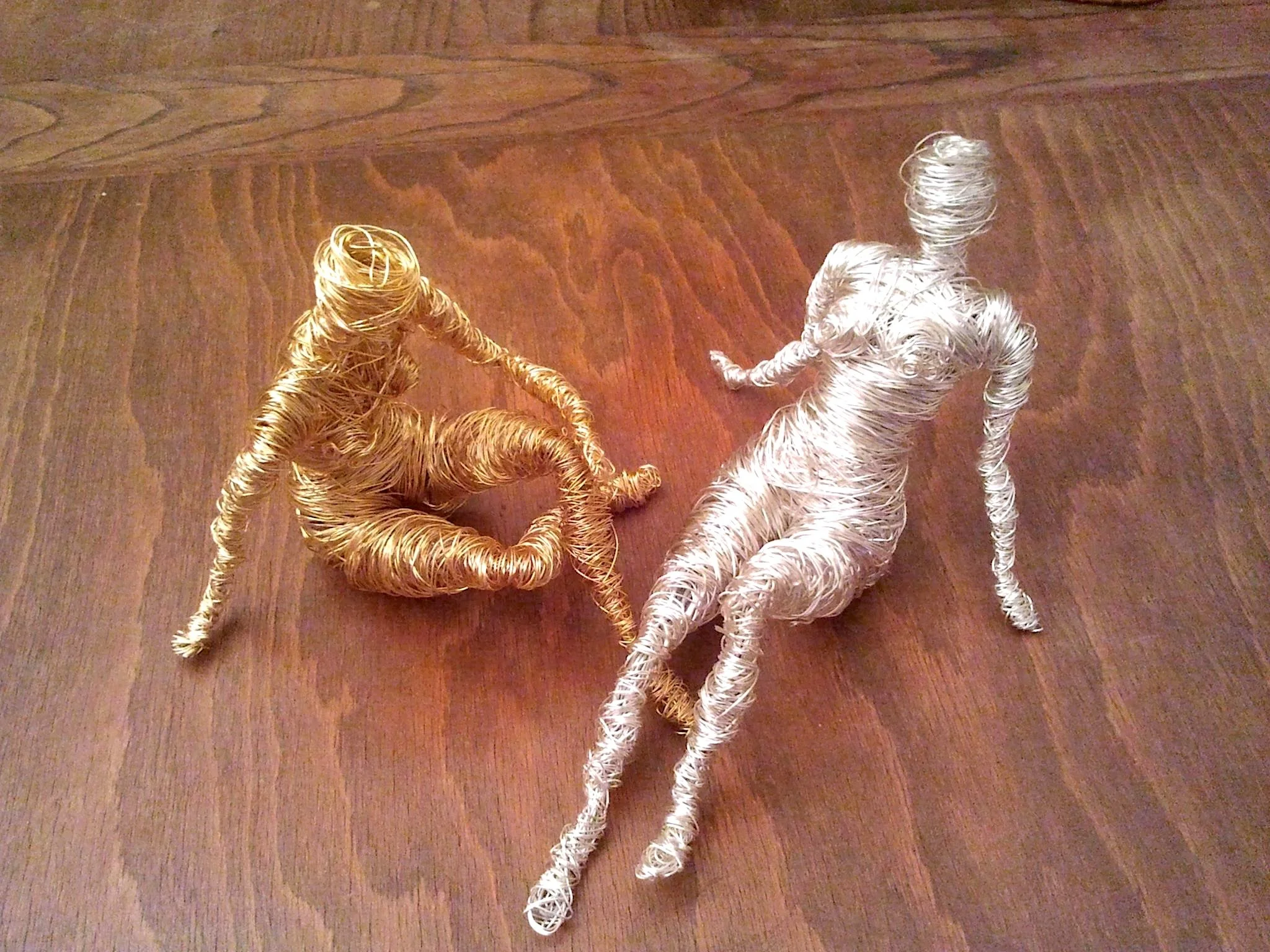 Deux sculptures de femmes assises, fil de fer doré et argent