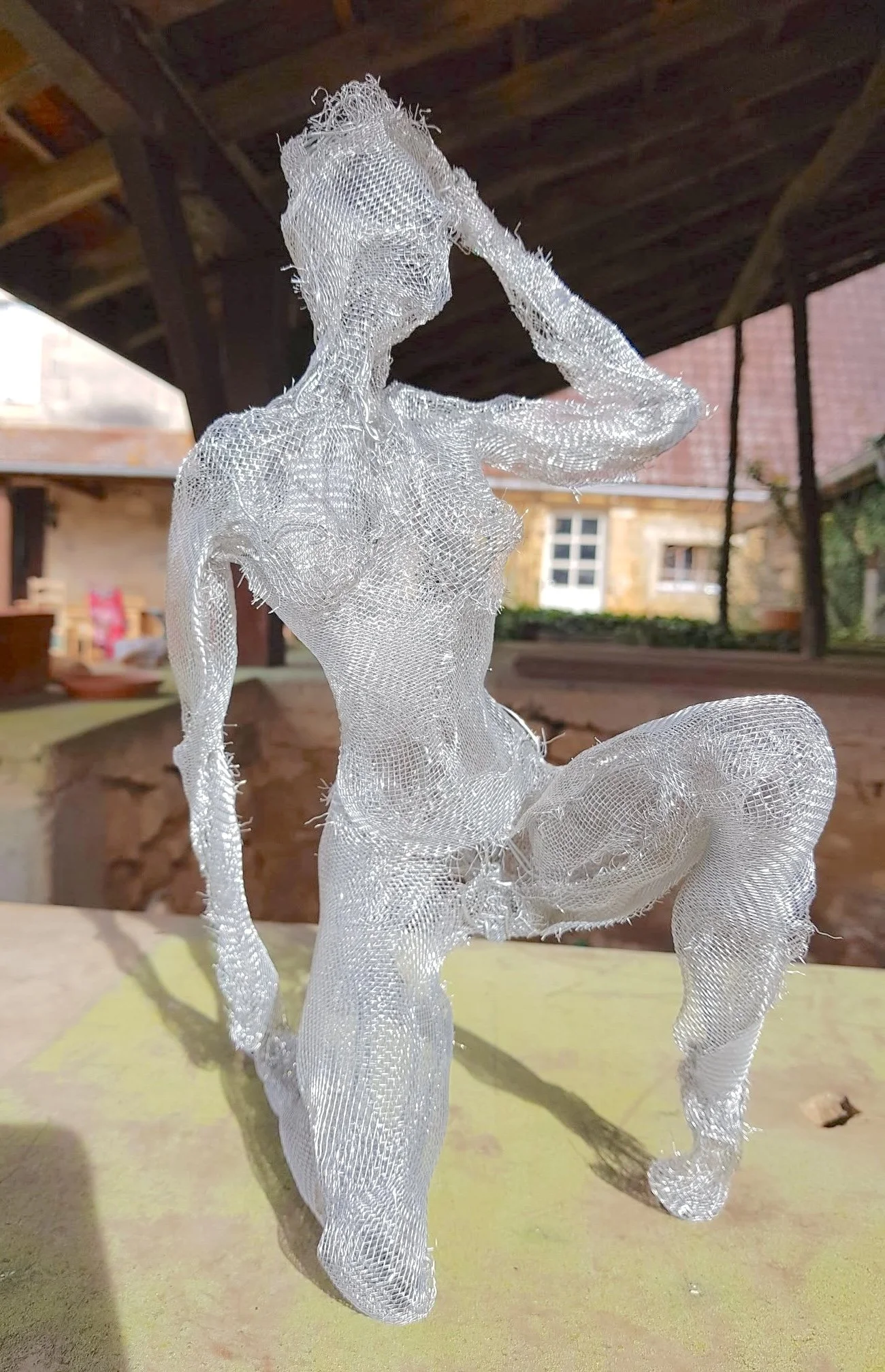 Sculpture de femme à genoux en toile moustiquaire
