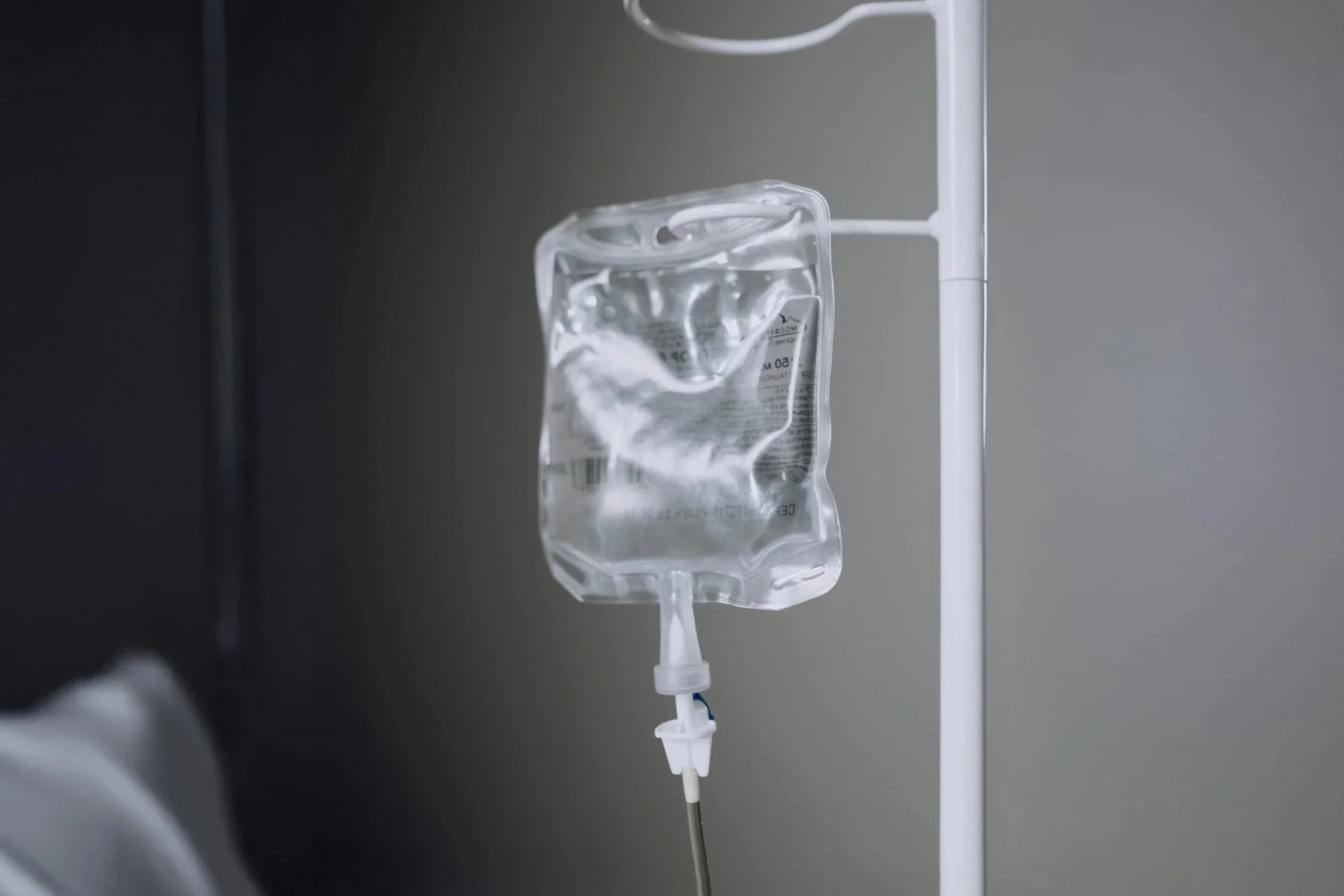IV drip bag hanging on a hospital stand with clear liquid inside