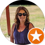 Woman smiling outdoors wearing sunglasses and a sleeveless top