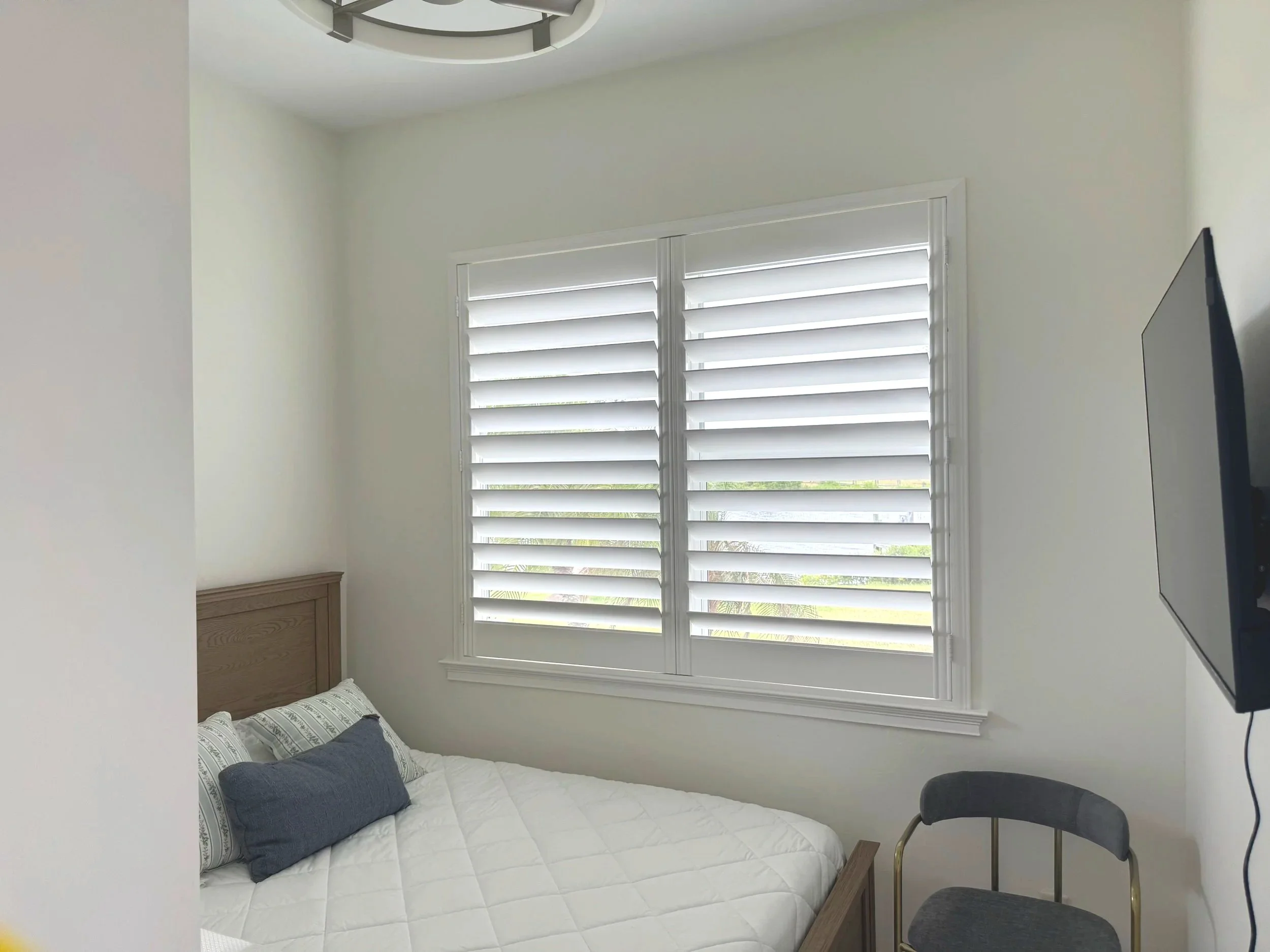 A TV mounted on a wall of a Port Charlotte Home over looking a bed