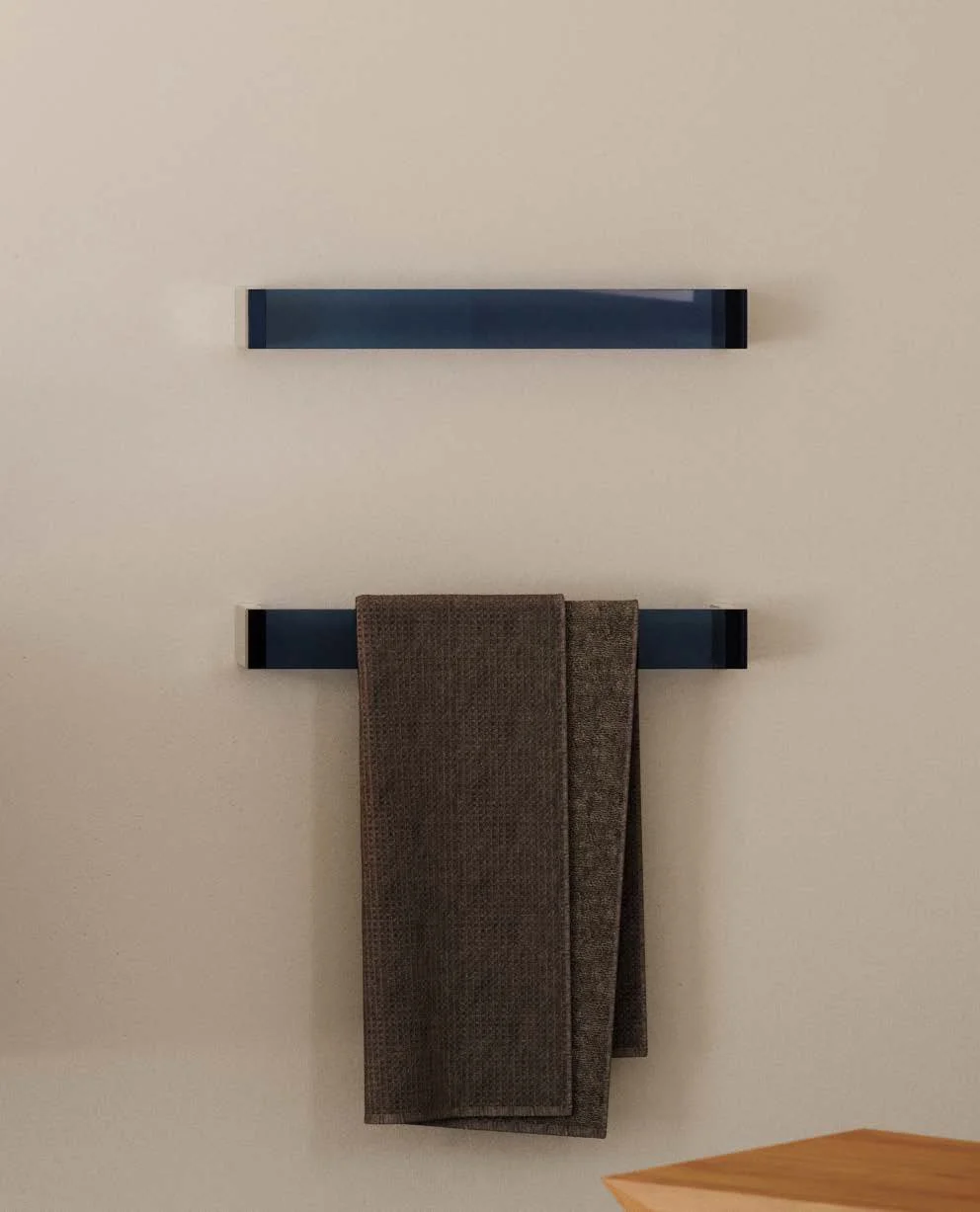 Two modern black wall-mounted shelves, one with a brown cloth hanging from it, against a plain light-colored wall.
