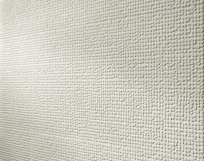 Close-up of a white textured wall with small, rounded, raised patterns.