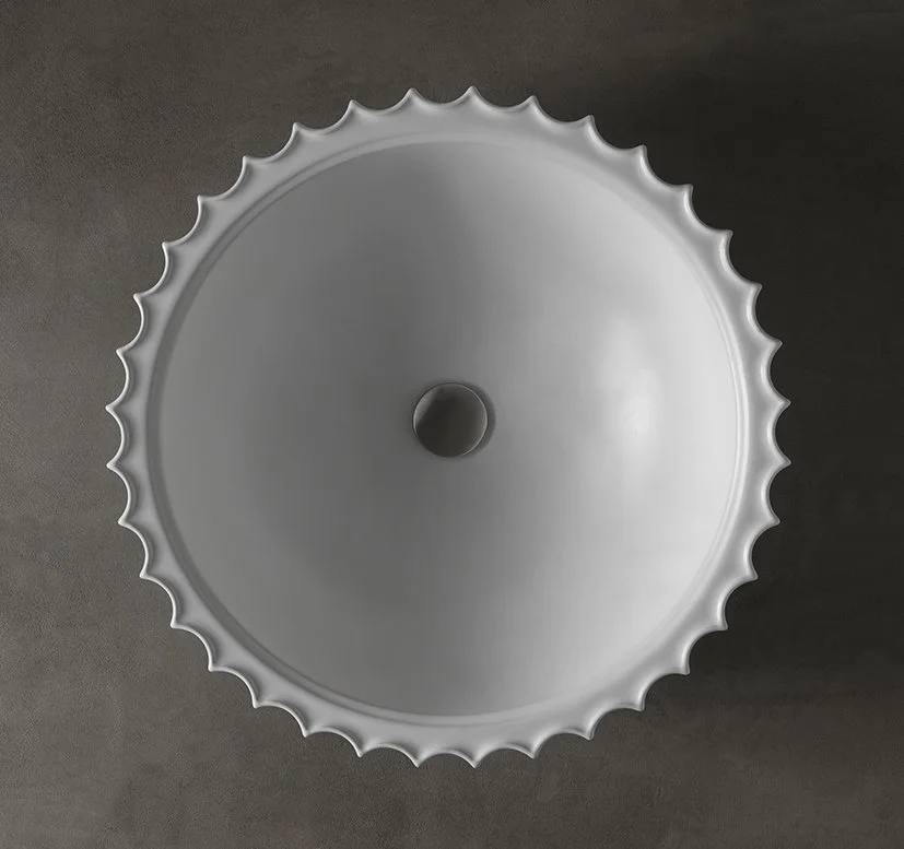 Top view of a circular saw blade with sharp teeth on a dark surface.