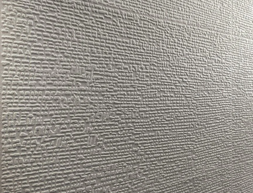 Close-up of a textured beige wall with a pattern of small, irregular ridges.