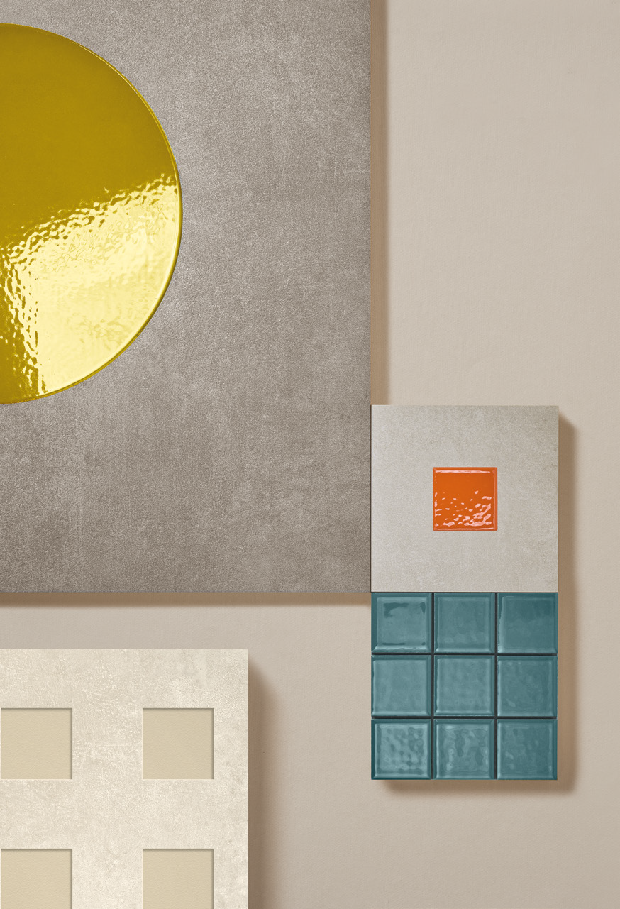 Close-up of modern decorative objects on a wall, including a yellow reflective circle, a small orange square, a block of teal tiles, and cut-out beige squares on a beige background.