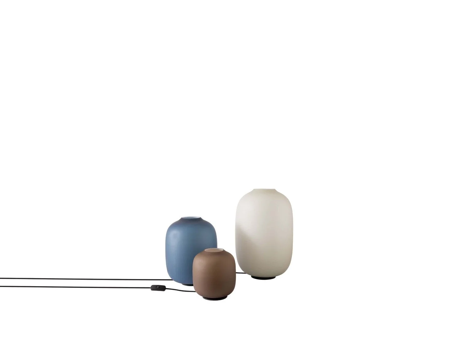 Three modern ceramic table lamps in blue, brown, and white, with a black power cord, set against a plain white background.