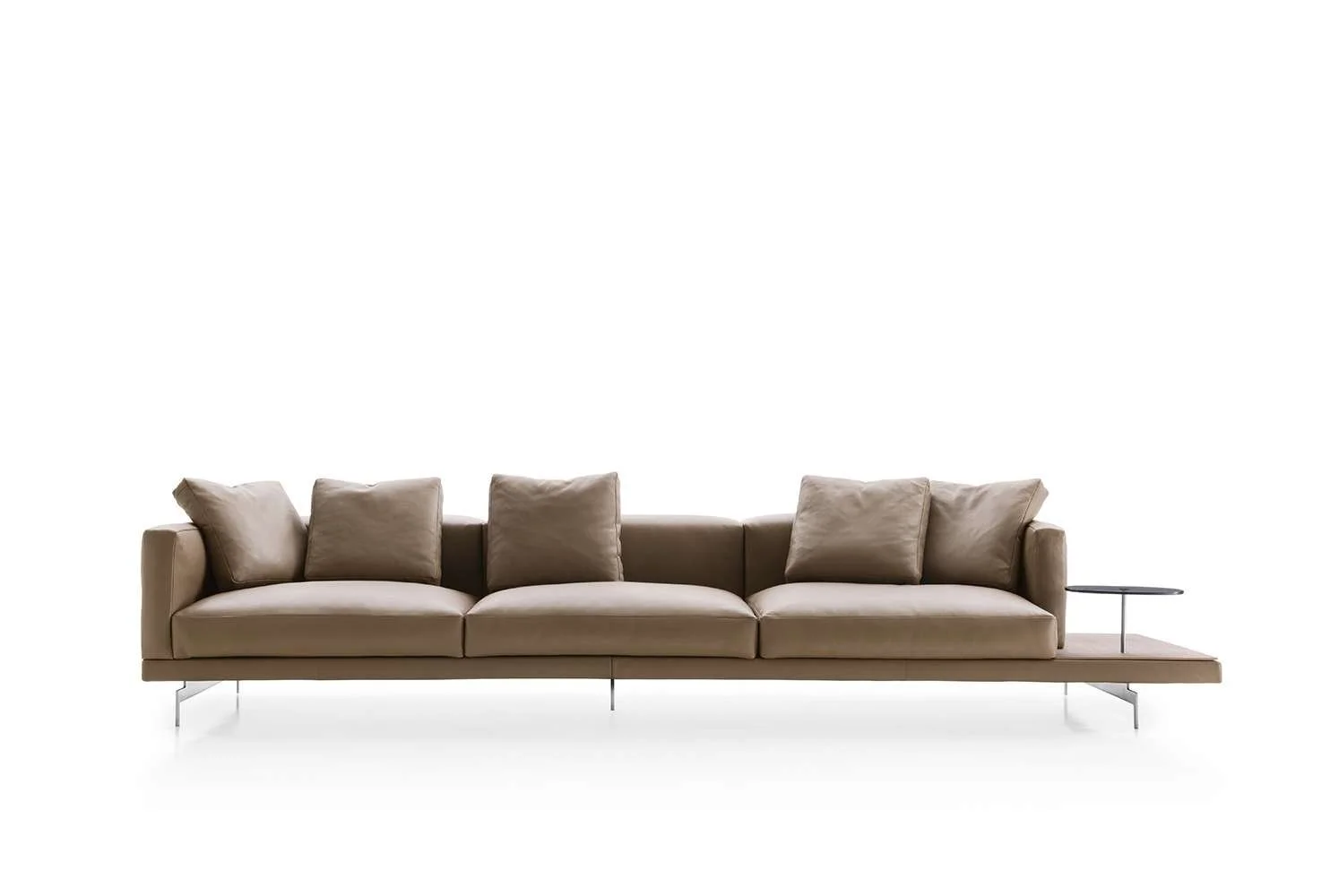 A modern beige sofa with five cushions and a small black side table on its right side, set against a white background.