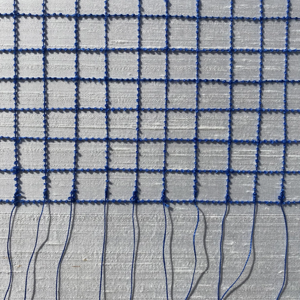 Close-up of a blue grid net with a plain light-colored background underneath.