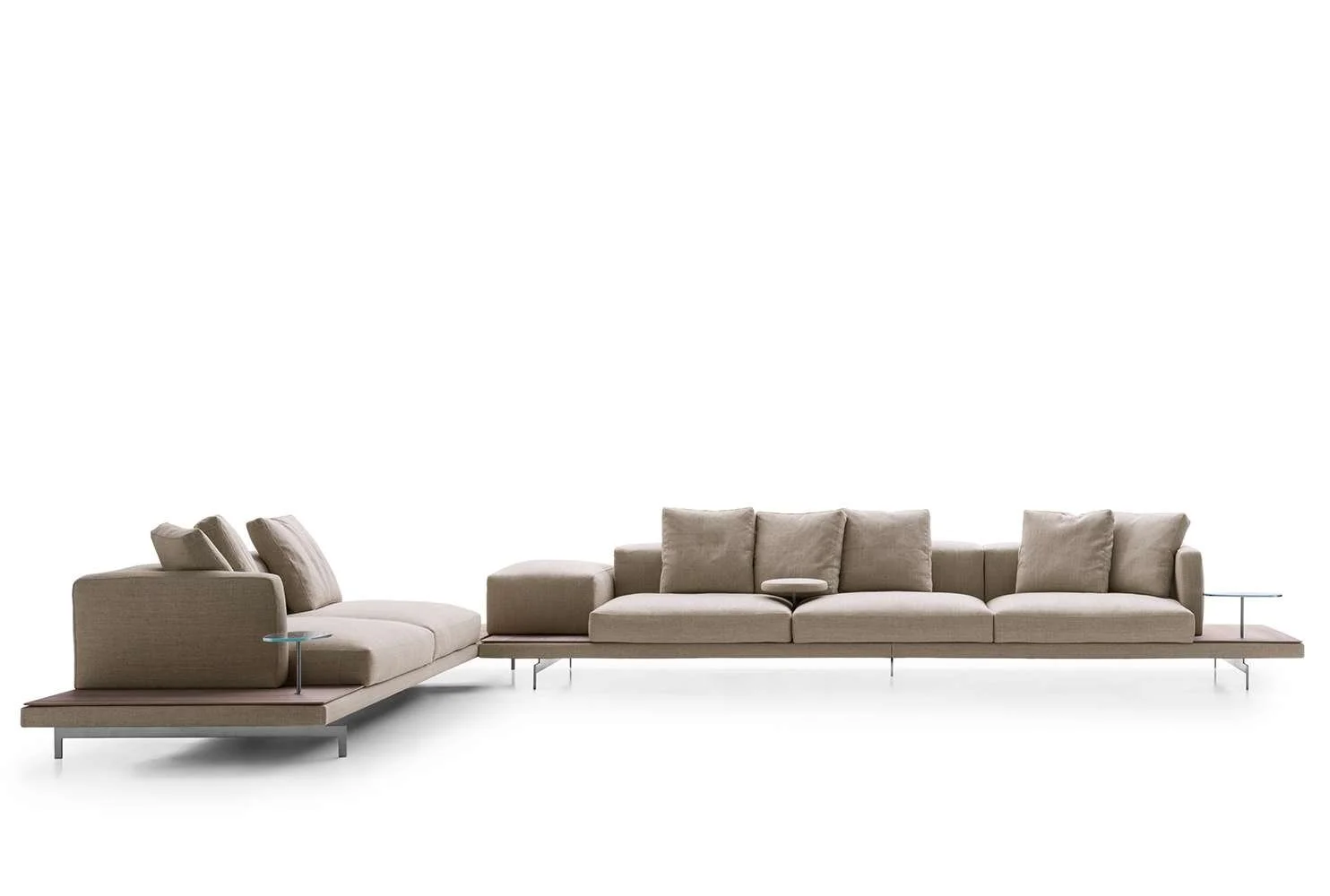 Modern beige sectional sofa with small side tables on a white background.