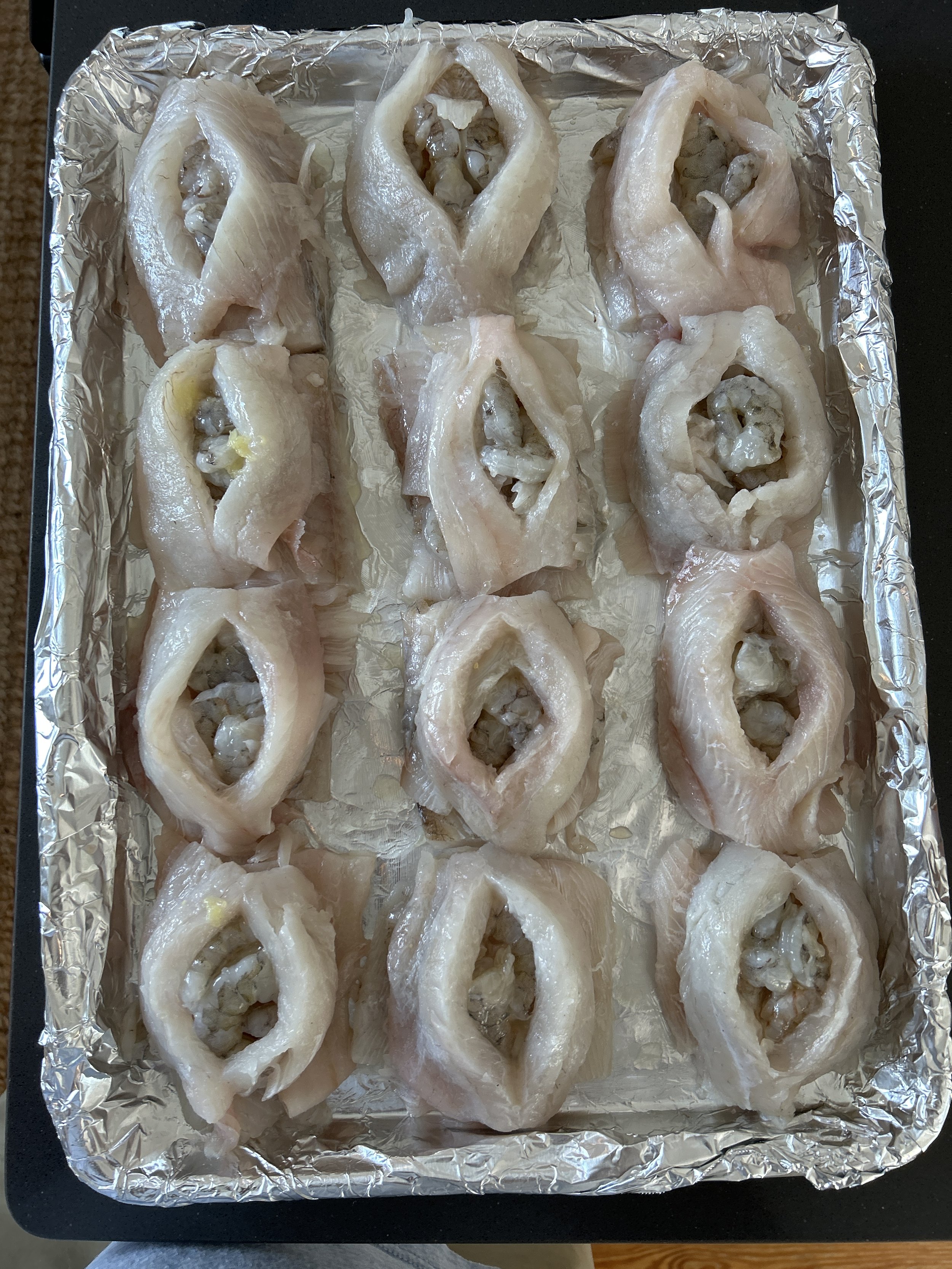 Raw fish fillets arranged on a baking sheet lined with aluminum foil, ready for cooking. sandbar Captain Tilly OC Fishing Charters. Ocean City, MD