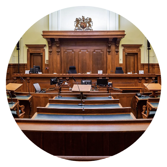 Empty courtroom with wooden furniture and a judge's bench.