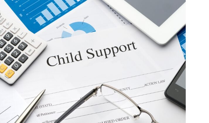 Child support document surrounded by calculator, glasses, pen, smartphone, and tablet.