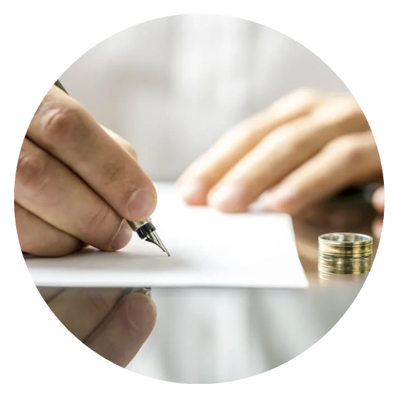 Person writing with a pen on paper, with coins stacked nearby on a reflective surface