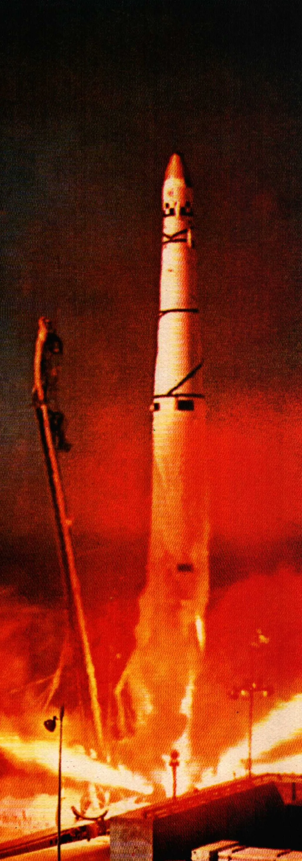 A rocket launch with flames and smoke, vertical flame plume rising from the base, night sky background.