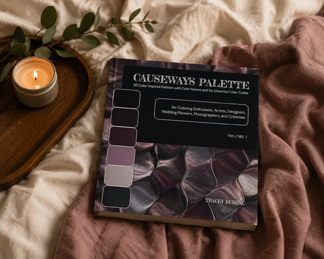 Mockup Image with Causeways Palette Color Inspired Book by Tracey Bureau lying on a beige and warm rust blanket next to a wooden tray with a sprig of greenery and a lit candle.PNG