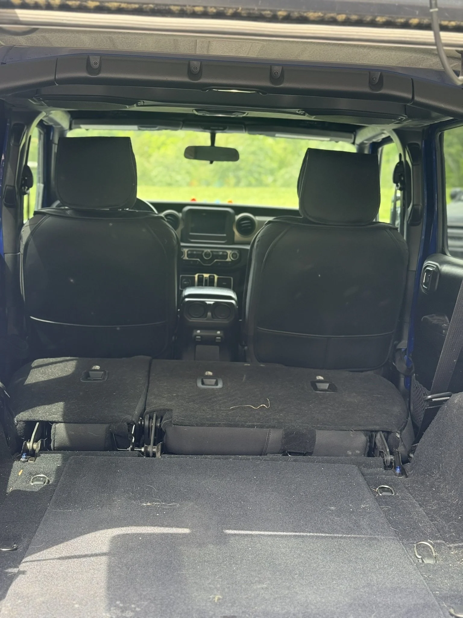 The interior of a vehicle showing the rear cargo area with the rear seats folded down, revealing a flat storage space.