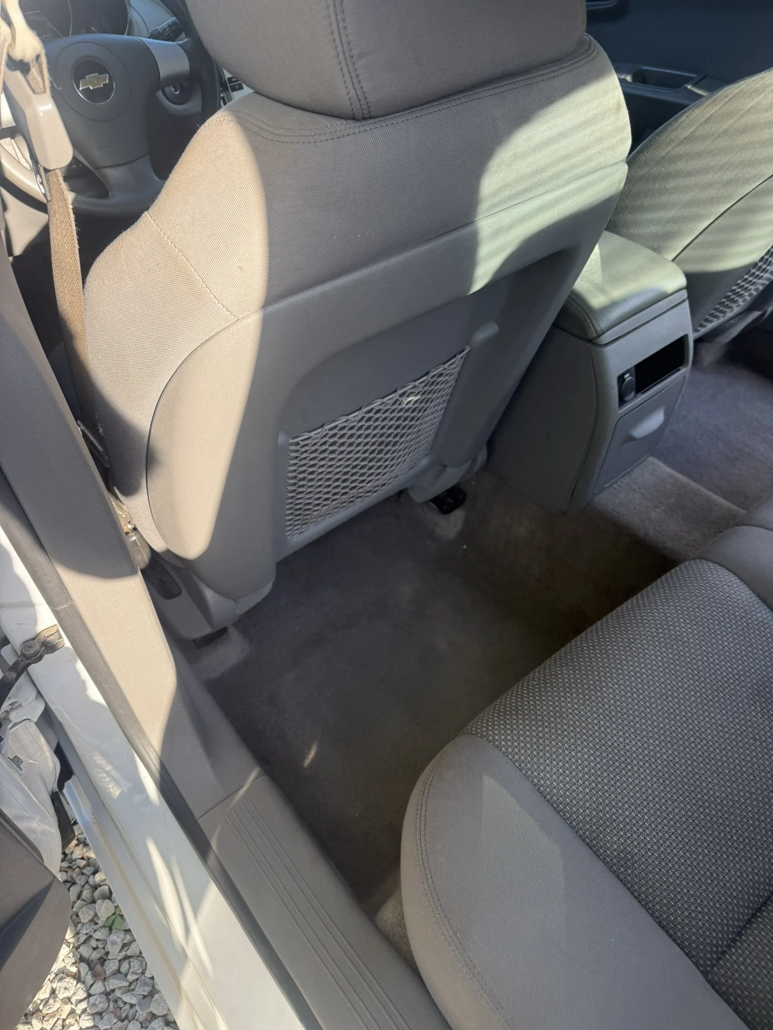 Interior of a car showing the back of the front seats, center console, and part of the rear seat.