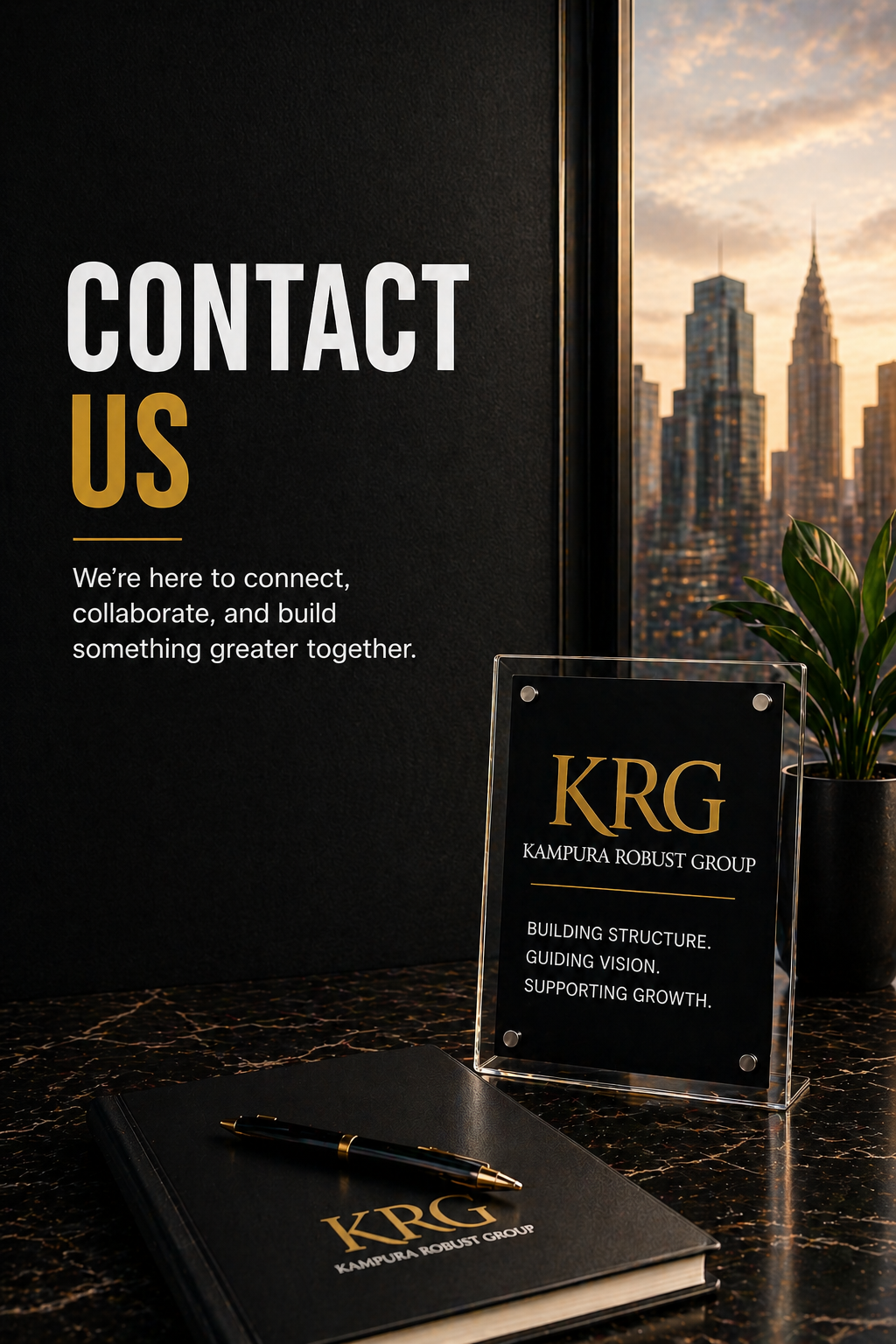 Contact Us sign on a dark wall with a city skyline in the window. A table with a planner, a pen, and an acrylic stand with KRG branding and company slogan.
