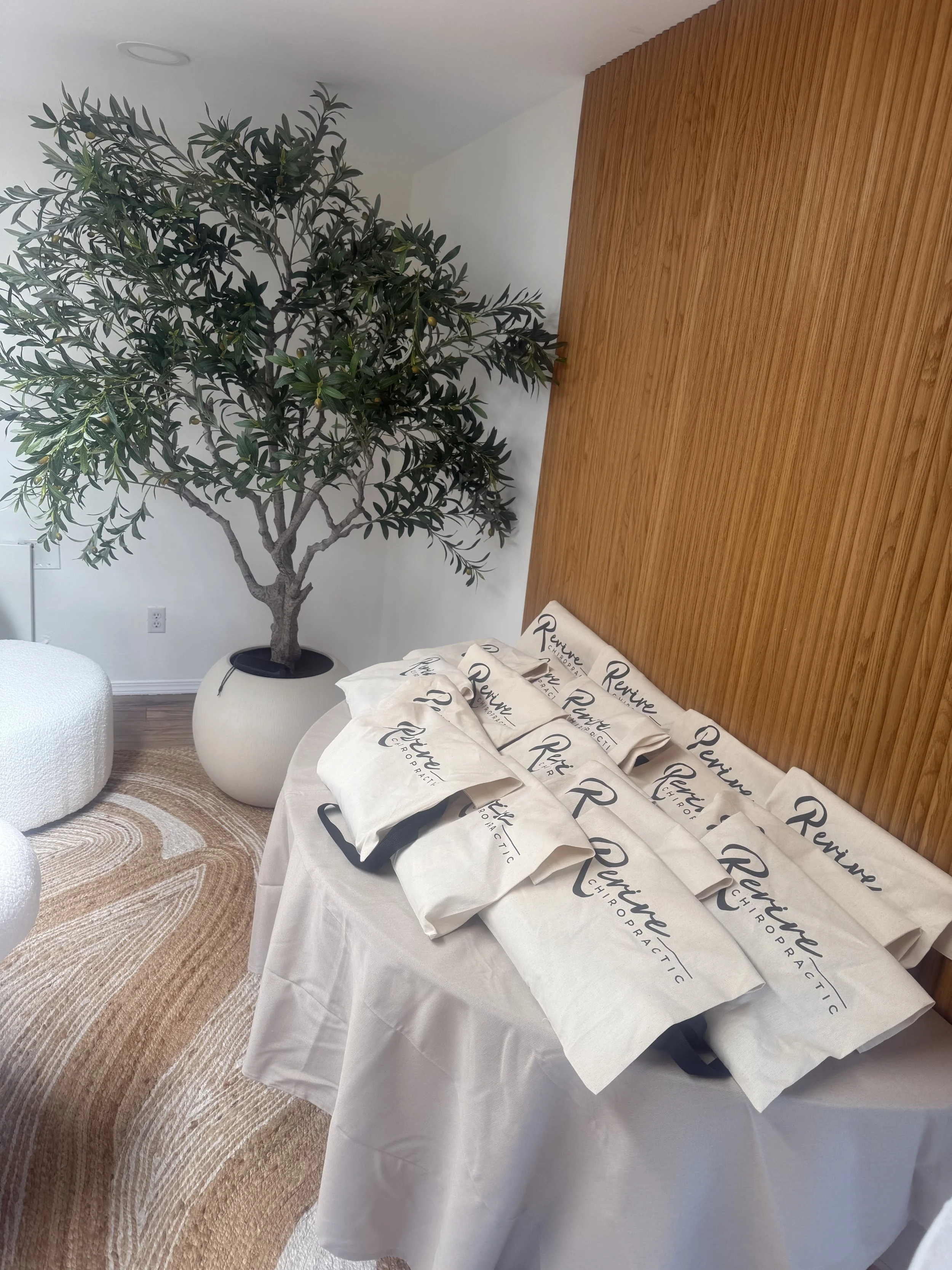 Rolled Revive towels beside the olive tree in the Point Loma event space