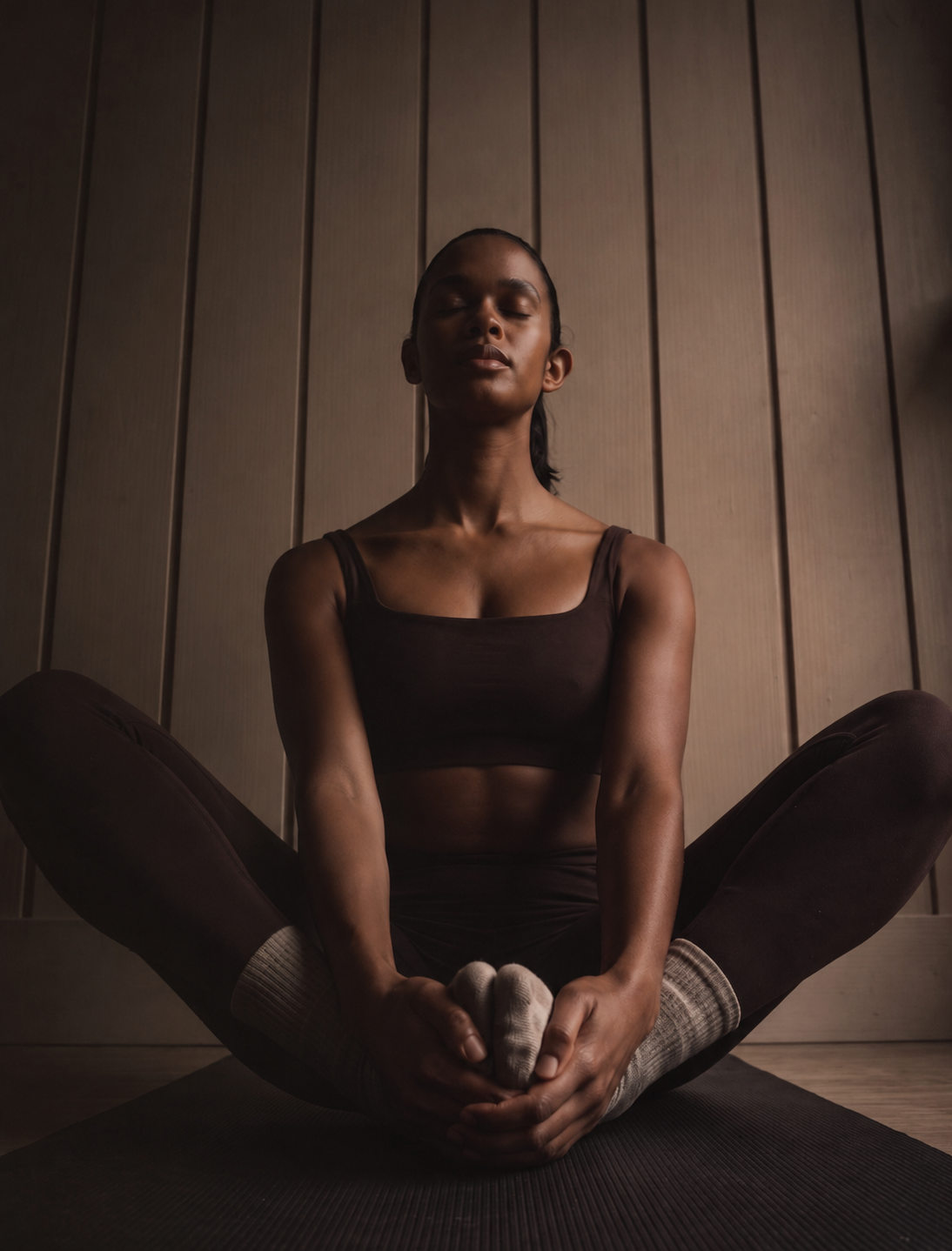 Woman seated in a restorative yoga pose representing integrated chiropractic and wellness care at Revive Chiropractic