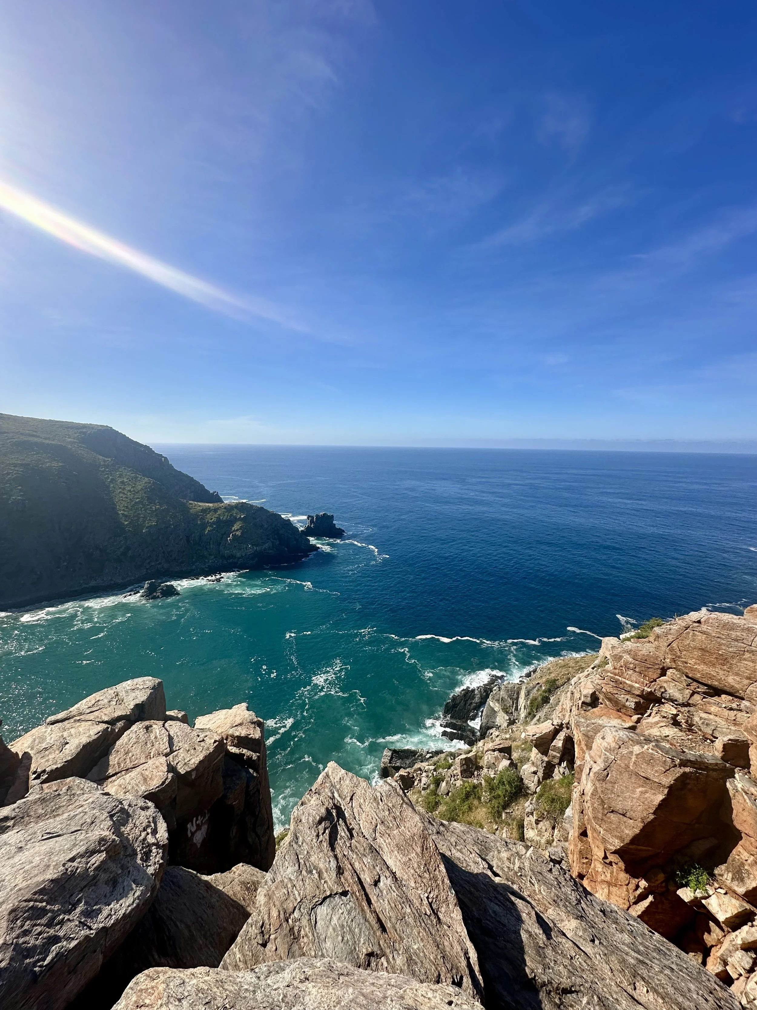 Dramatic rocky cliffs overlooking turquoise and deep blue ocean waters in Todos Santos, Mexico