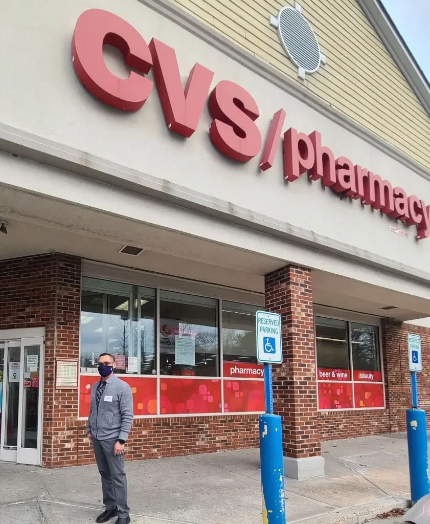 Man standing outside CVS pharmacy wearing a face mask.