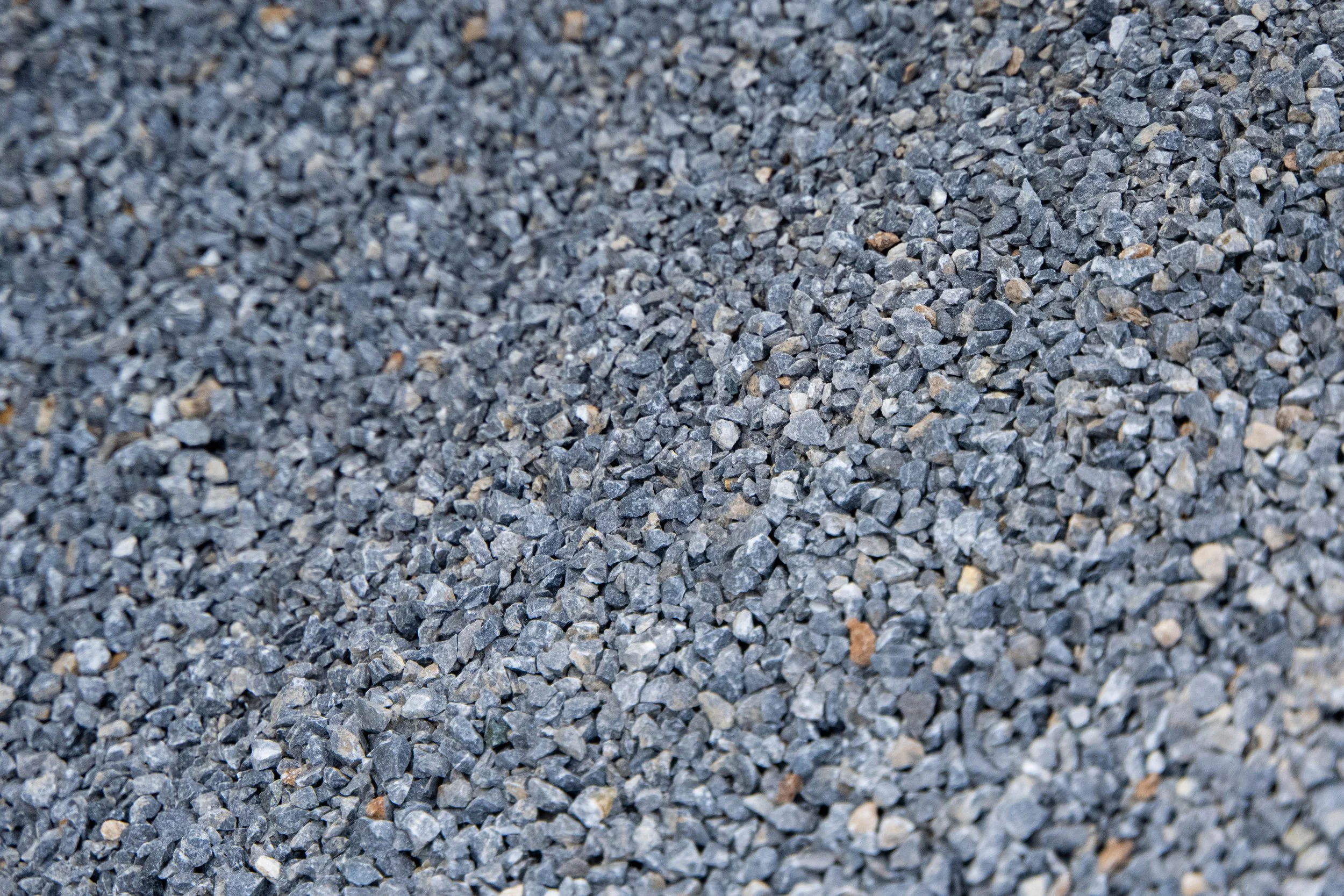 Close-up of small, irregular gray gravel stones covering a surface.