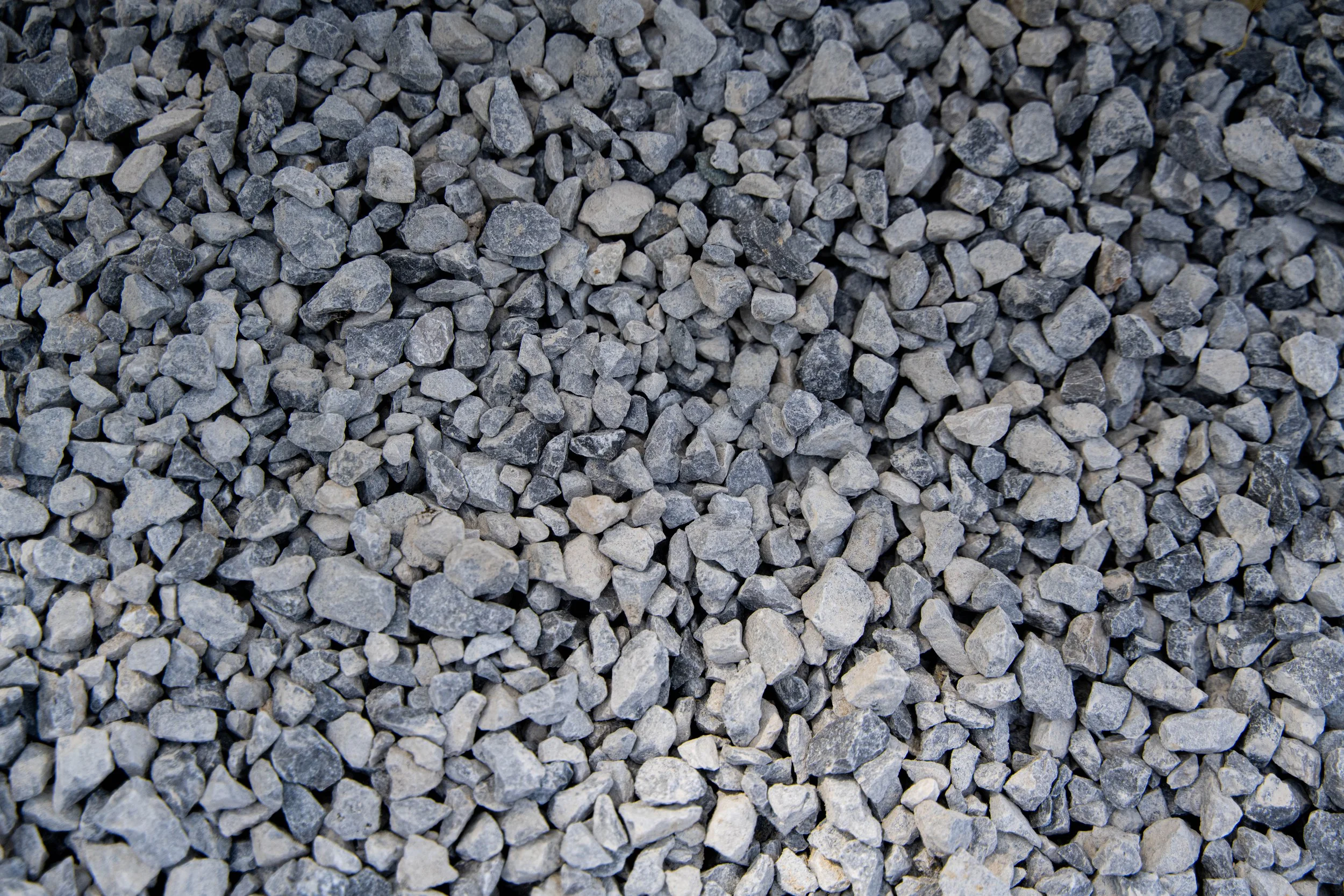 A close-up view of small gray gravel stones with various shapes and textures.