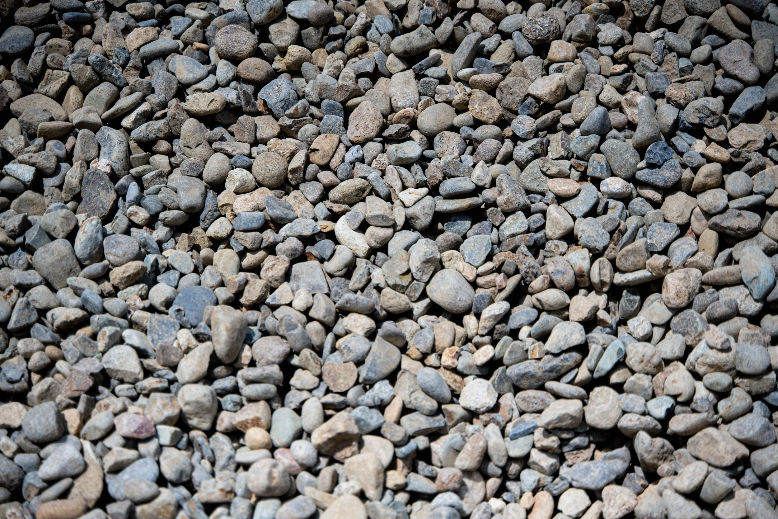 A close-up view of small, multicolored gravel stones spread evenly across the ground.