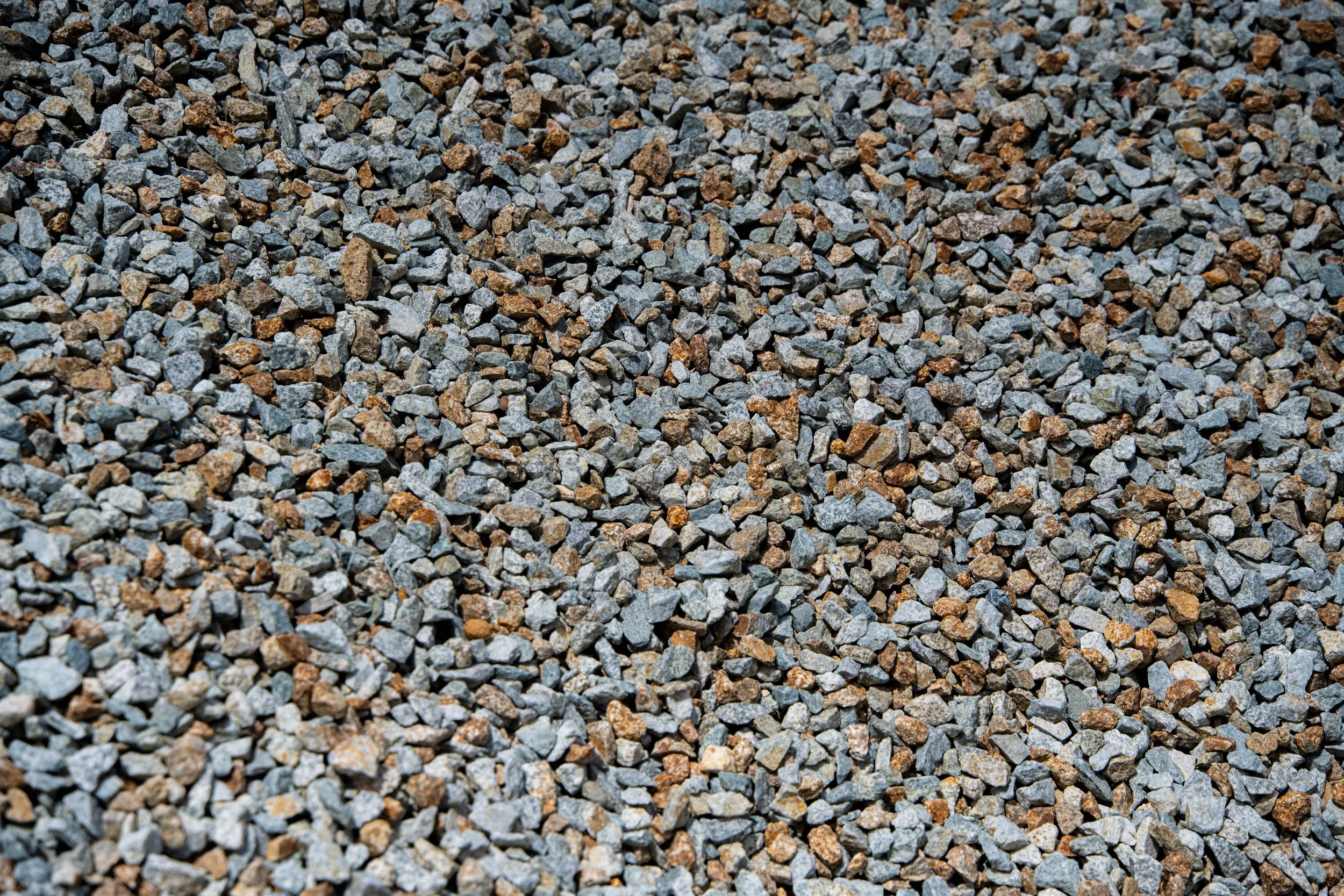 Close-up of small gray and brown gravel stones covering the ground.
