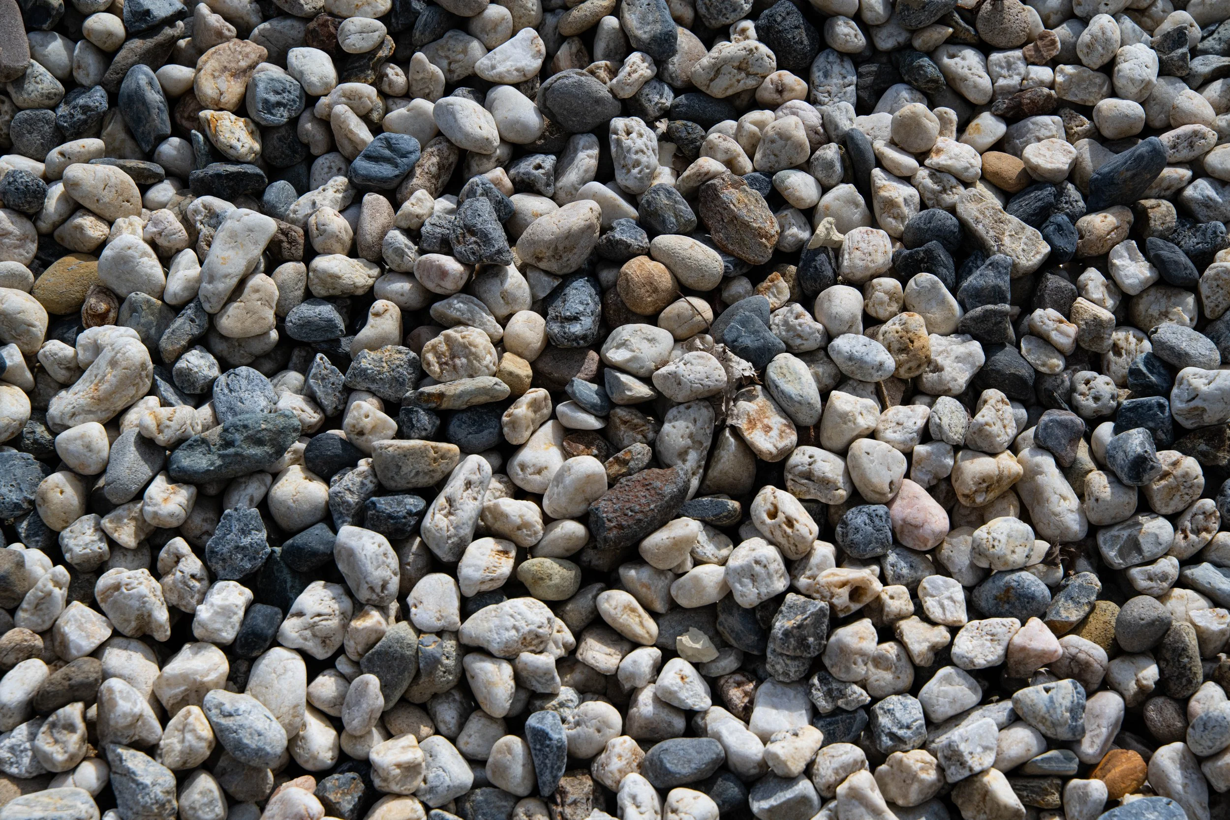 Close-up of small multicolored pebbles and stones scattered on the ground.