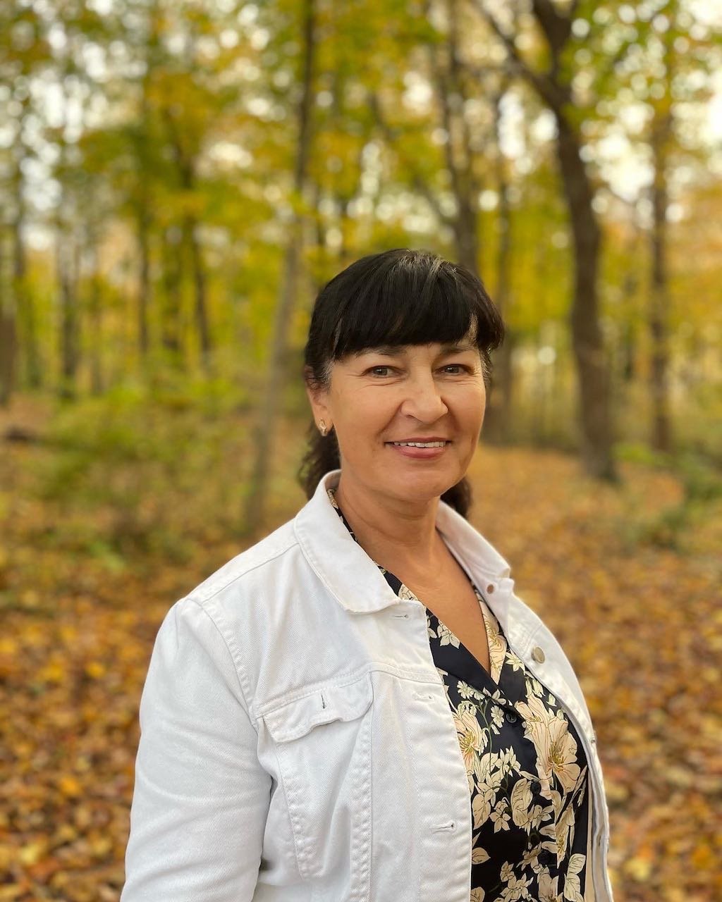 Liliya of HopeWell Reiki standing outdoors in autumn trees