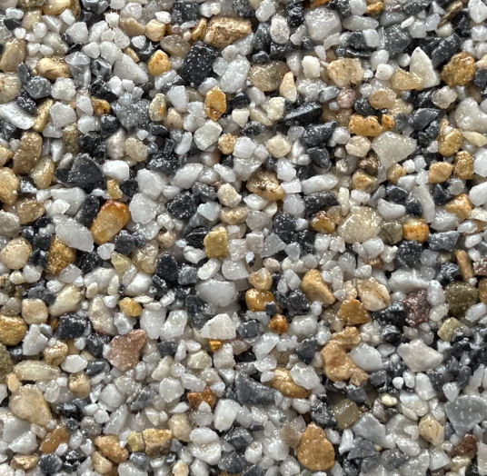 Close-up of multicolored gravel stones, including white, black, beige, and tan, on a surface.
