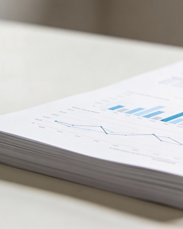 Close-up of a printed report with blue line and bar graphs showing data trends on white paper.