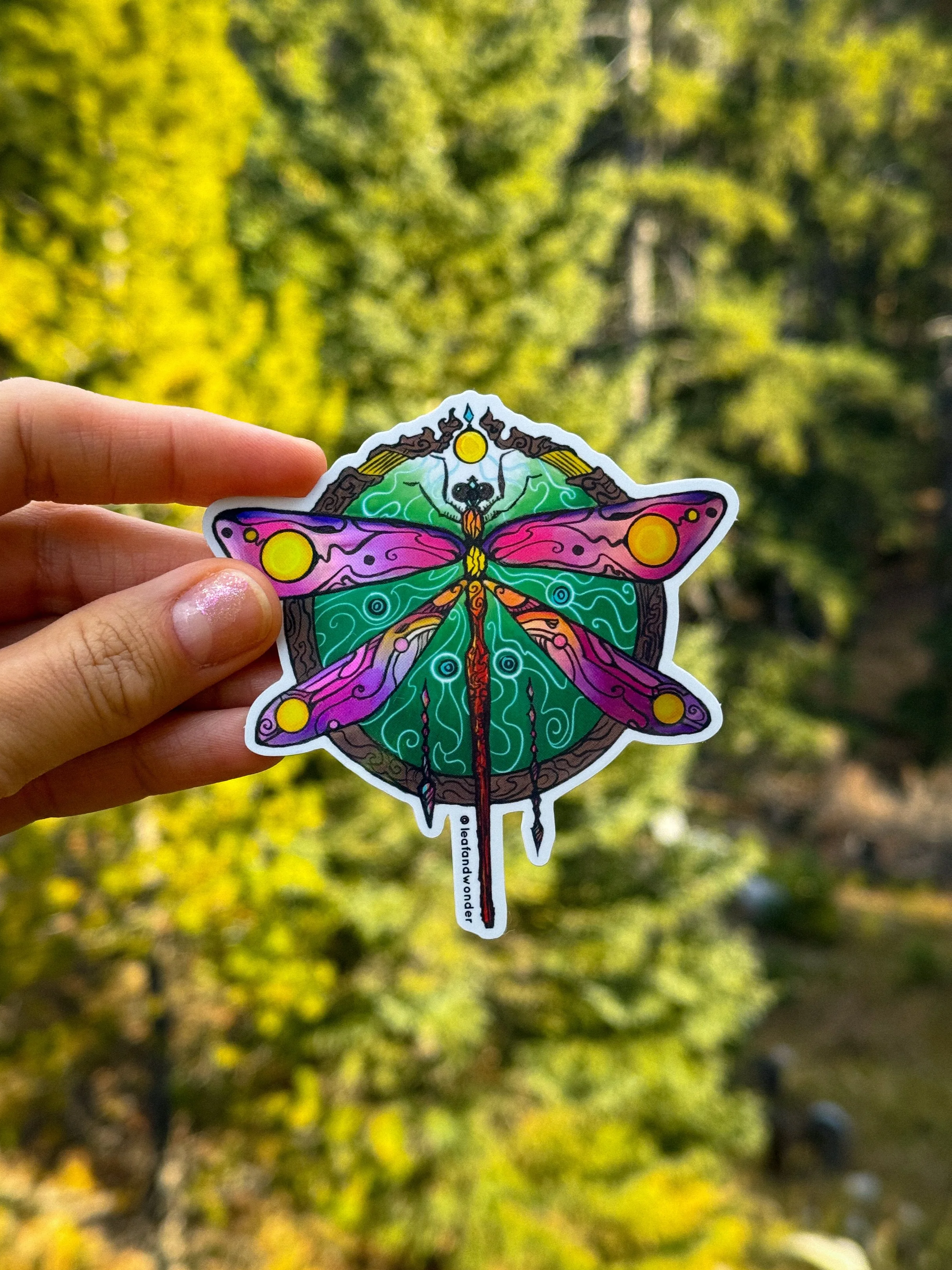 A large dragonfly sticker with ornate details in bold colours.