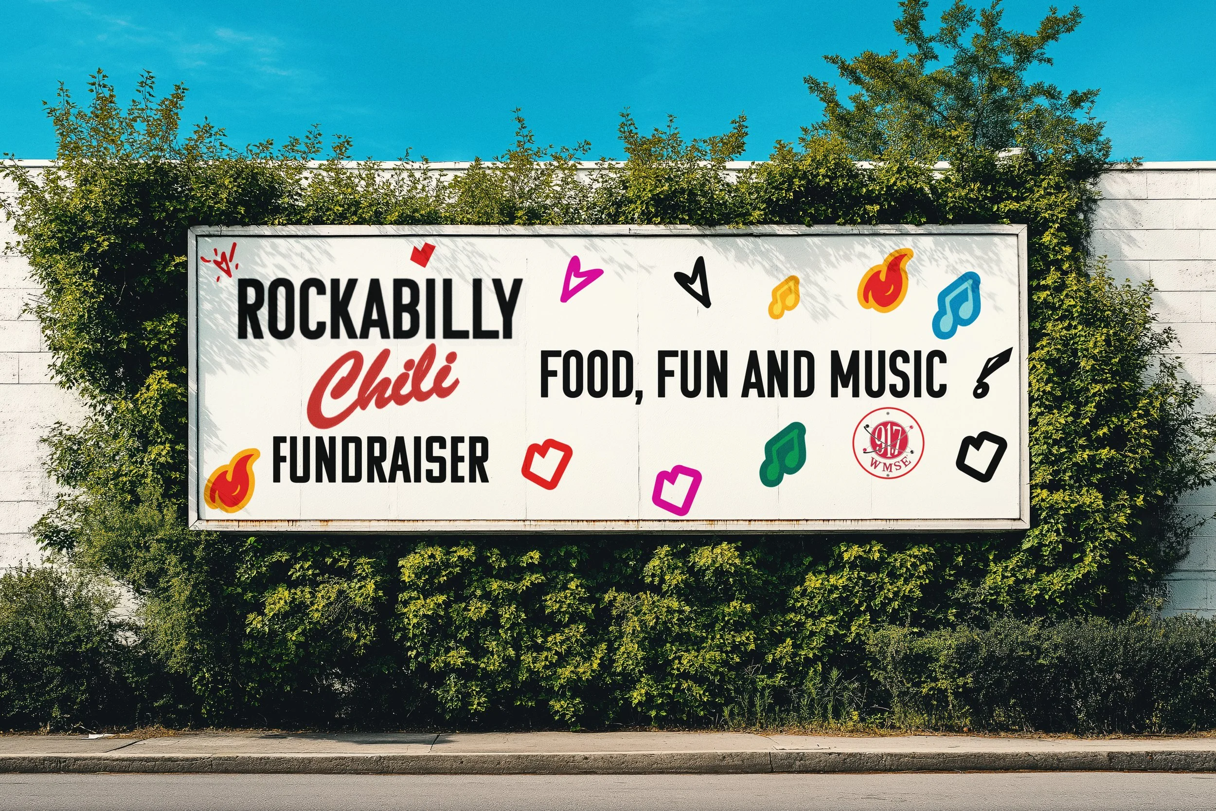 Large outdoor billboard promoting Rockabilly Chili event with text about food, fun, music, and fundraiser, decorated with colorful musical notes and fun symbols, surrounded by green bushes under a clear blue sky.