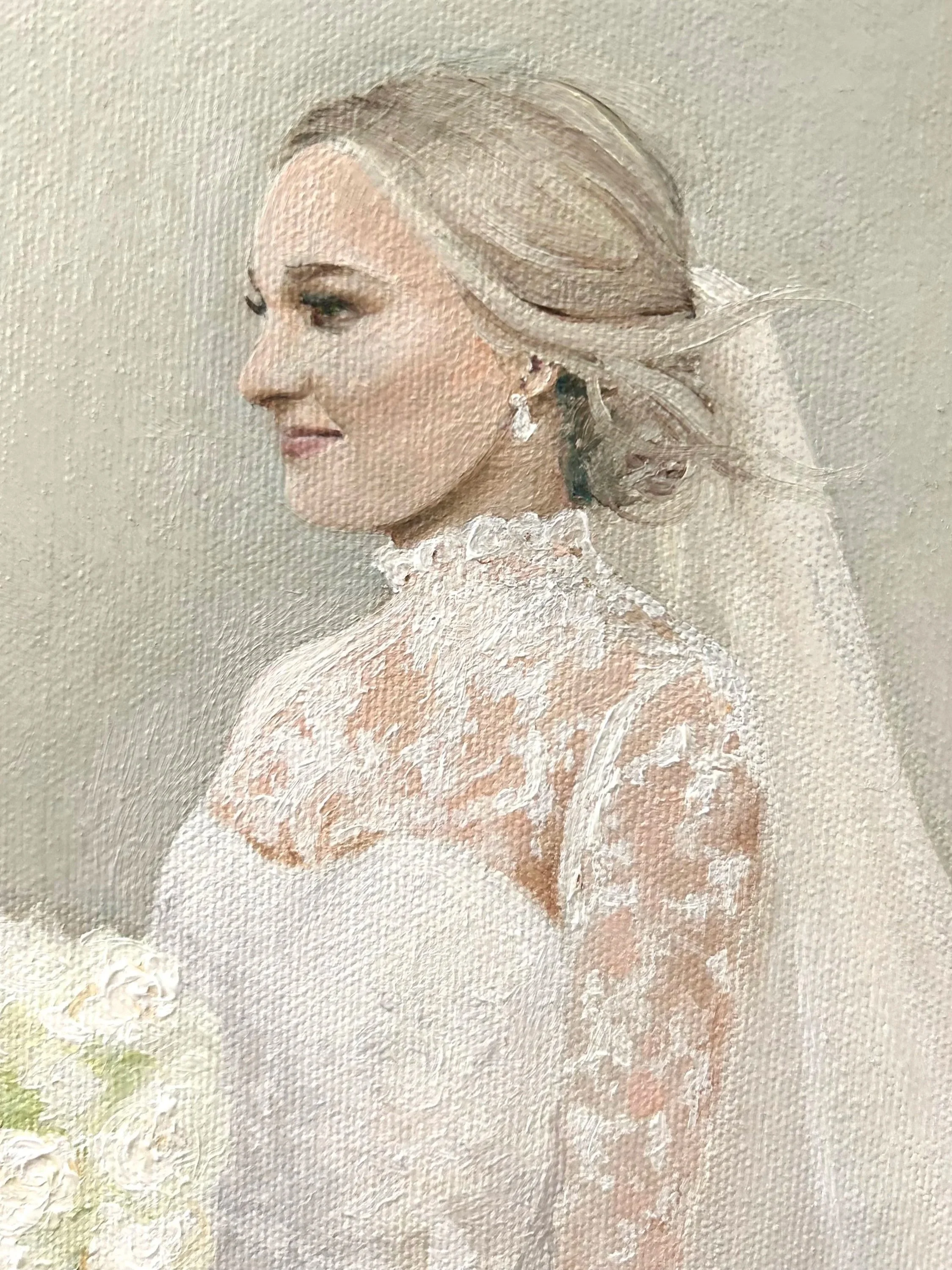 A portrait of a woman in a white wedding dress with lace details, with her hair styled in an elegant updo and wearing a drop earring.