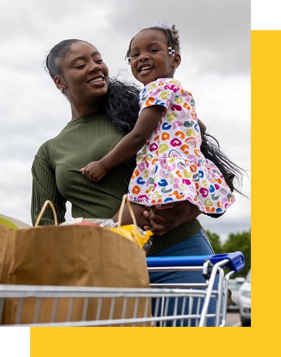 Photo of a mother and young girl with a grocery cart
