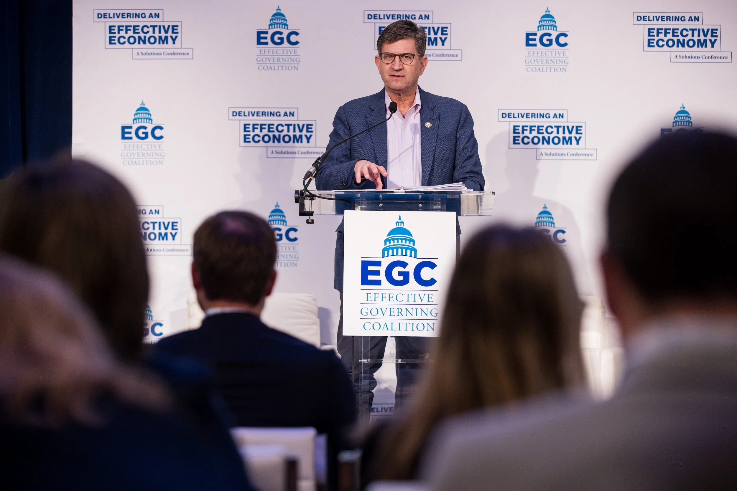 Rep. Brad Schneider speaking at a lectern with a sign that says EGC