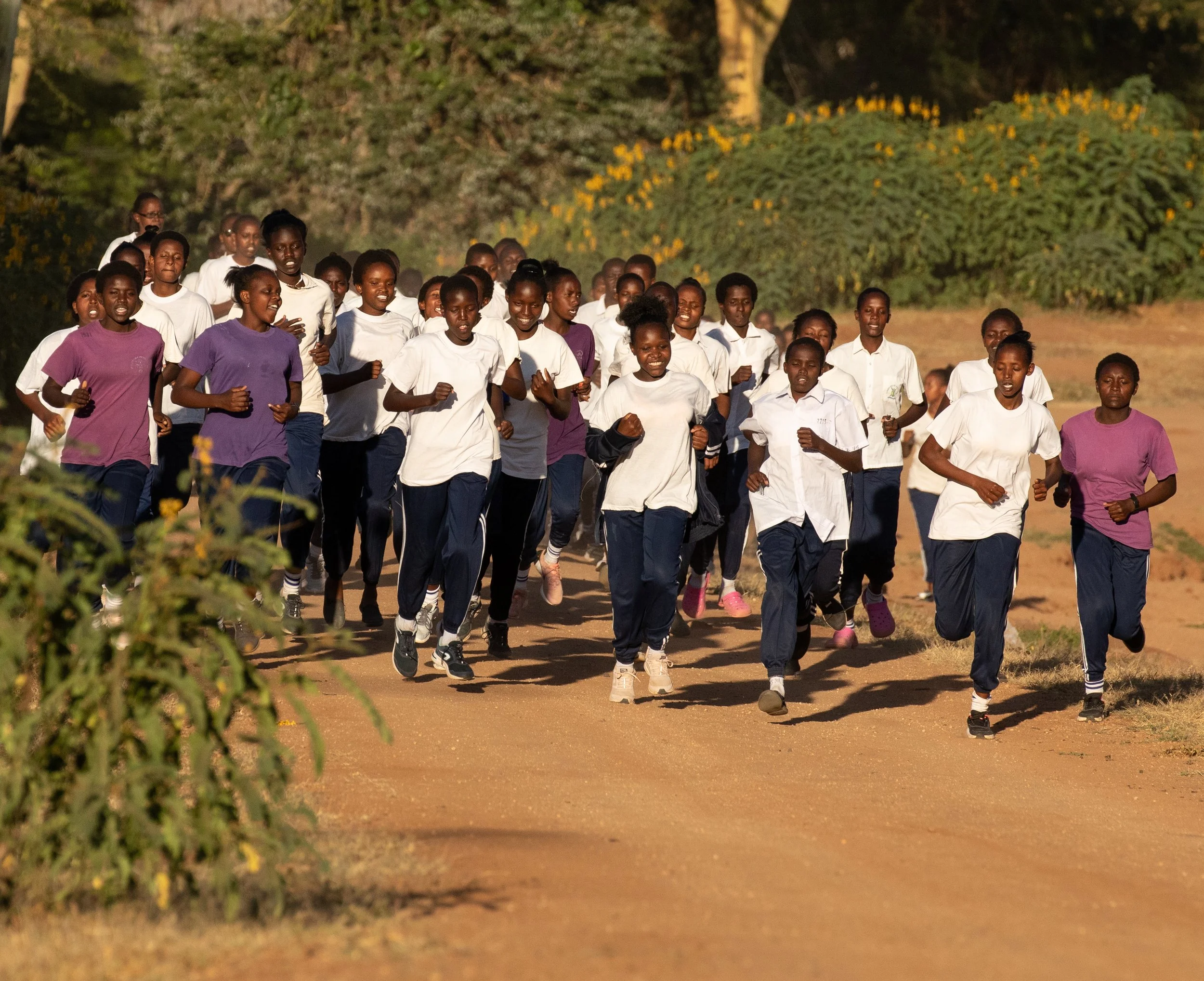 Group of Kenyan girls running together and smiling