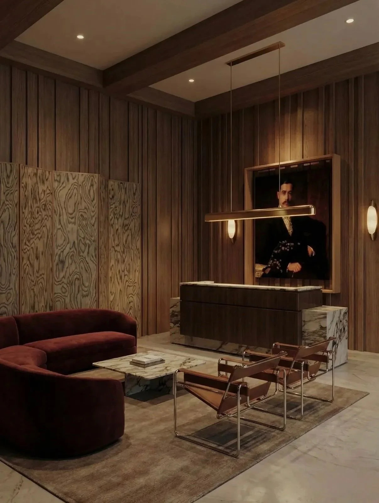 Sala de estar con paredes de madera, un sillón de terciopelo rojo, una mesa de mármol, una pintura de un hombre en el fondo, y una lámpara suspendida de color dorado.
