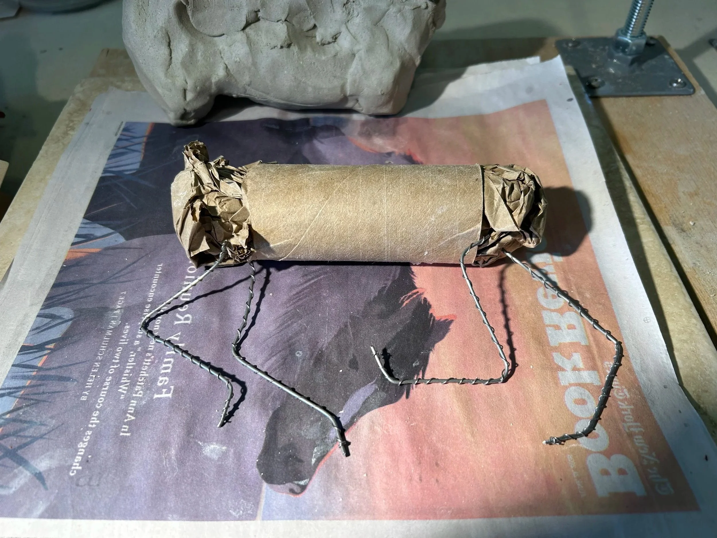 I start with a rough scaffold of toilet paper tube, paper, and high temperature wire.  I place a written prayer, poem or intension around the tube which burns away during the firing process.