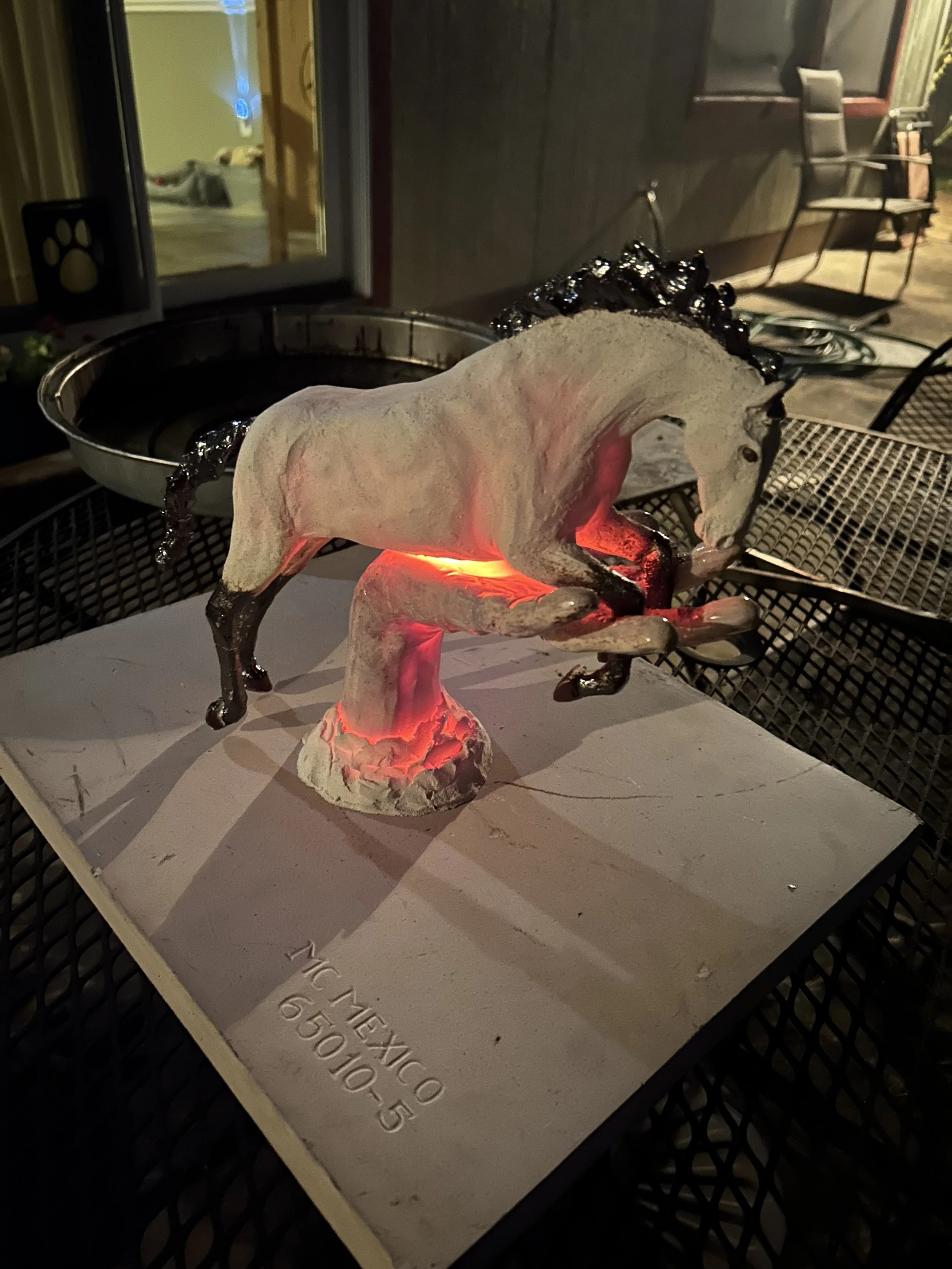 This is another sculpture pulled from the kiln still glowing hot and waiting to be put into the reduction bin.