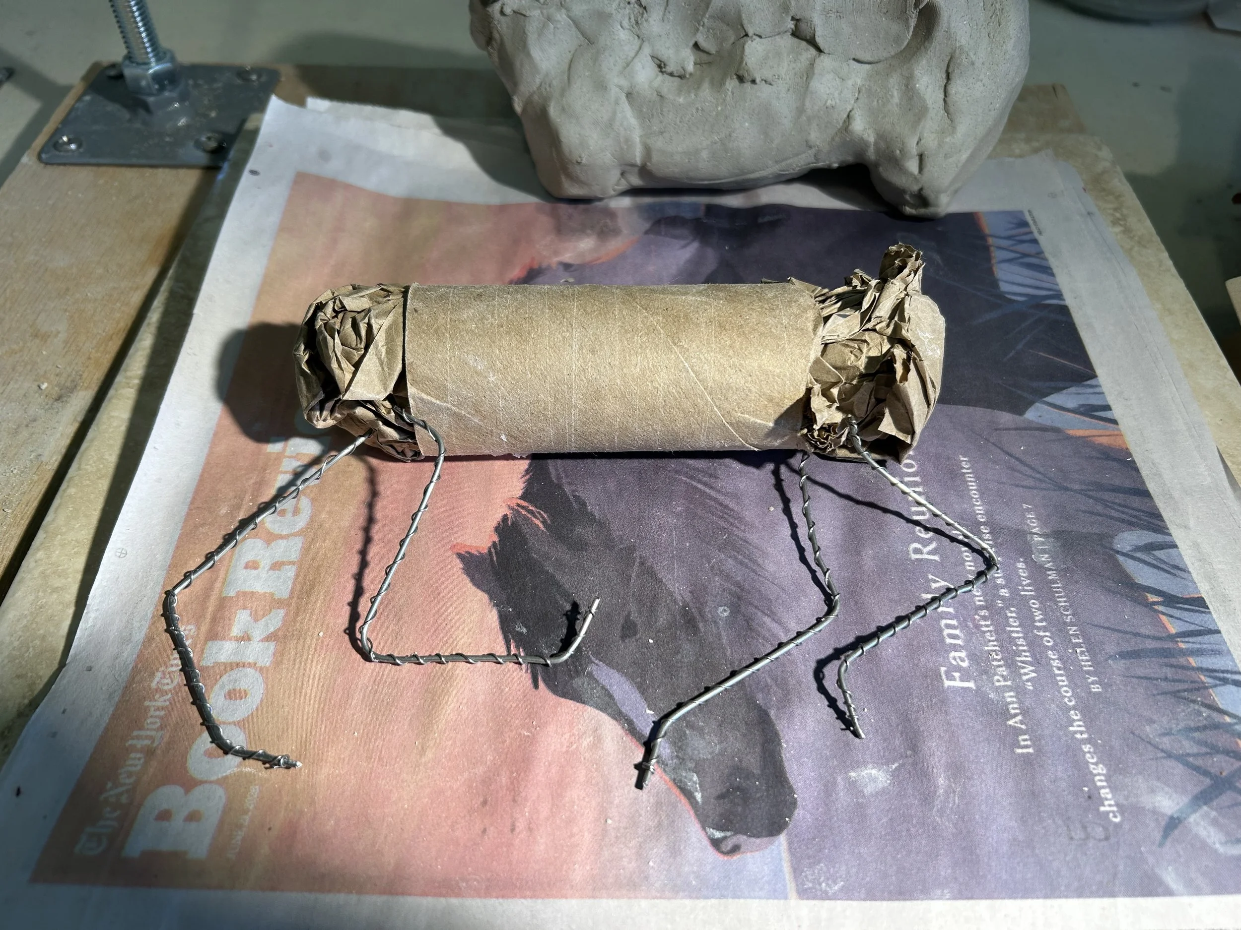 I start with a rough scaffold of toilet paper tube, paper, and high temperature wire.  I place a written prayer, poem or intension around the tube which burns away during the firing process.