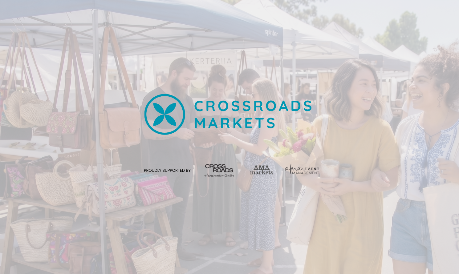 People shopping at Crossroads Markets outdoor market stalls, browsing handbags, flowers, and other goods on display under white tents on a sunny day.